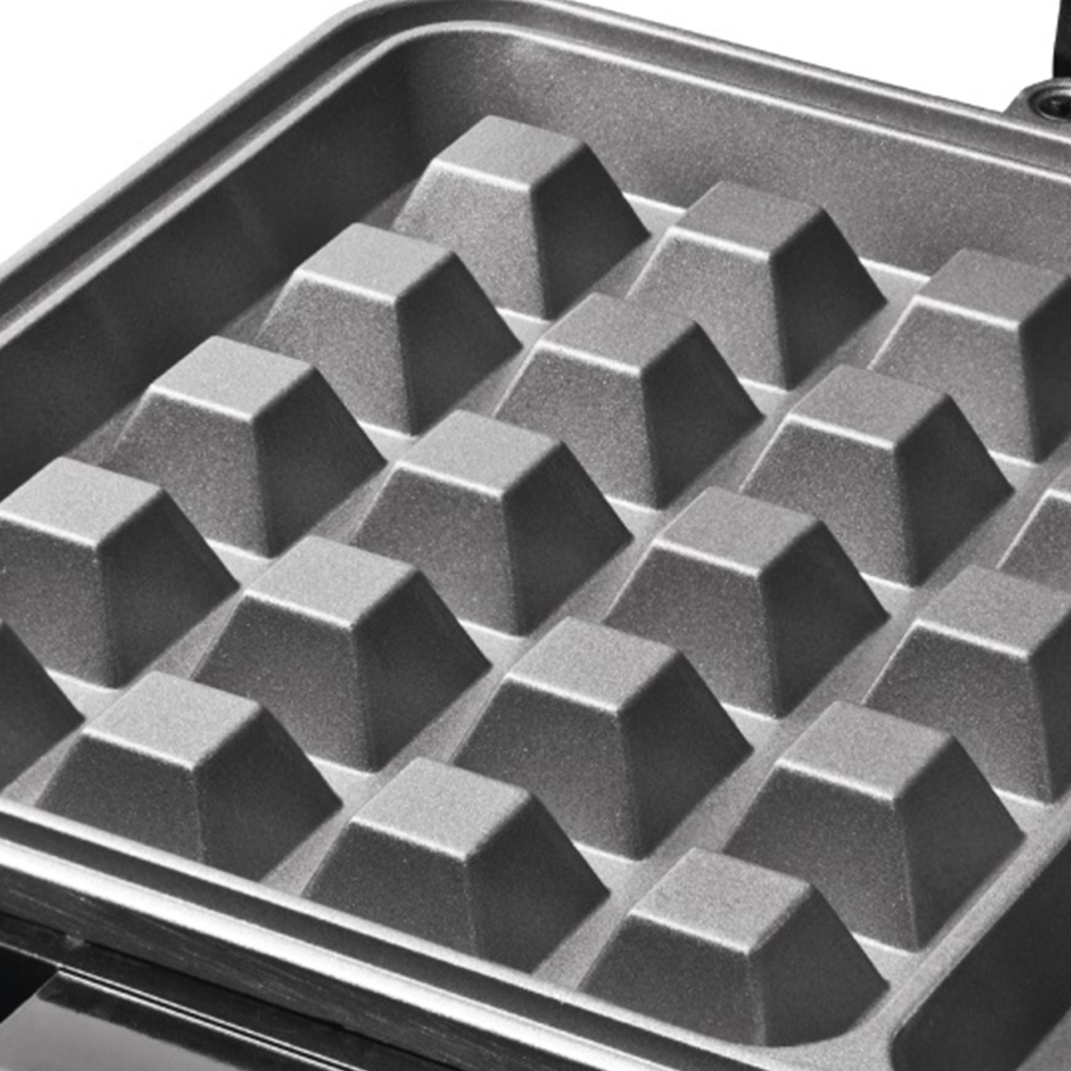 Interno di una piastra per waffle con un motivo a griglia di rientranze quadrate, grigio.