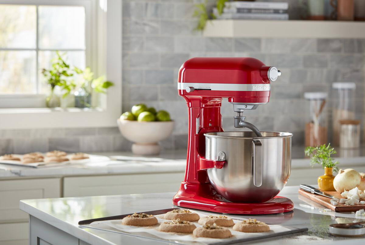 Roter KitchenAid-Mixer auf der Theke, Kekse auf dem Tablett, Limetten.