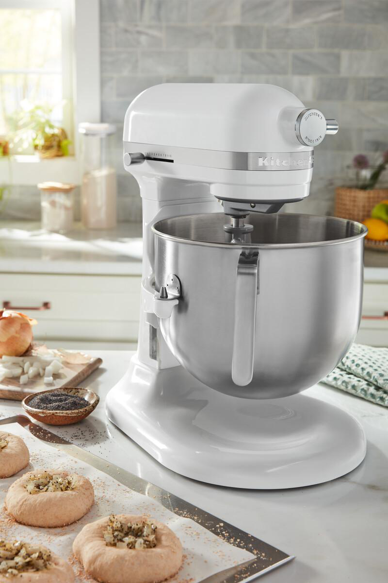 Weißer KitchenAid Mixer in der Küche. Zutaten und Backwaren auf der Theke.
