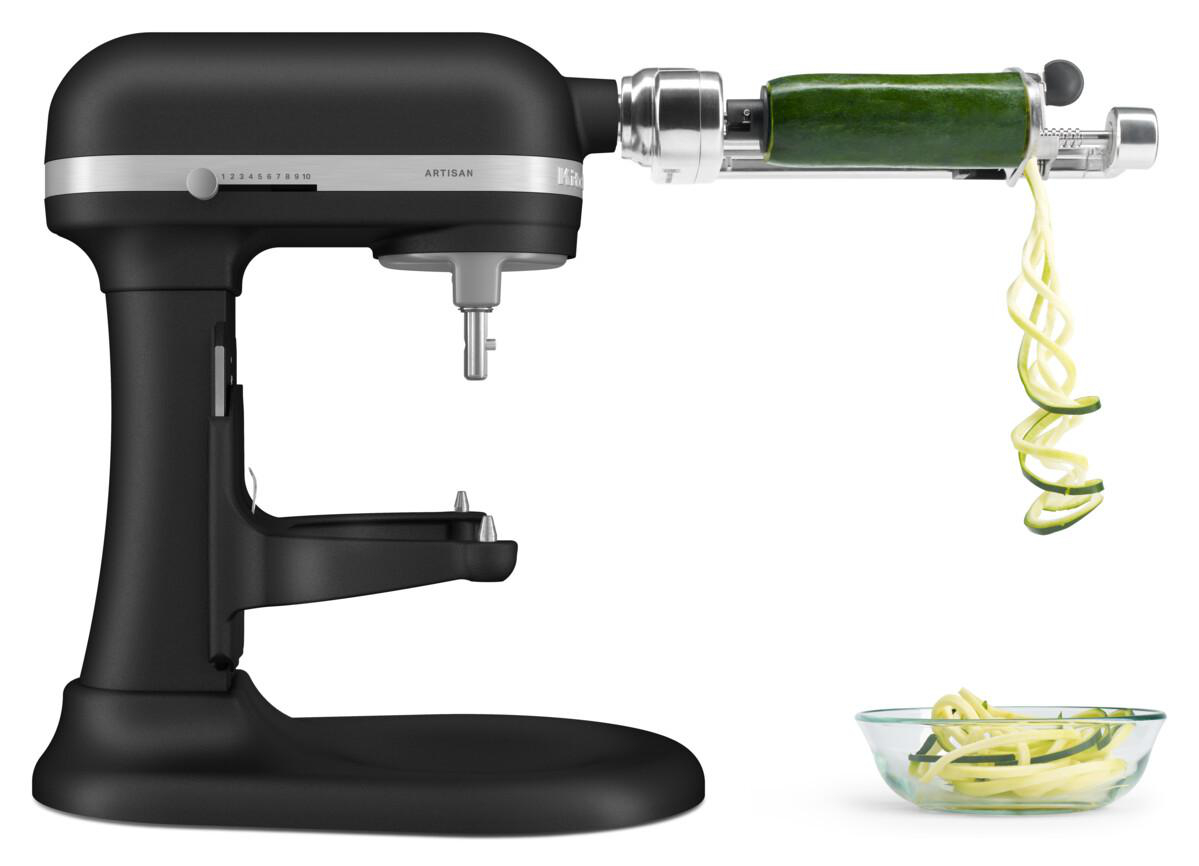 Schwarze KitchenAid Küchenmaschine mit einem Zucchini-Spiralschneider. Zucchini wird in eine Glasschale spiralförmig geschnitten.