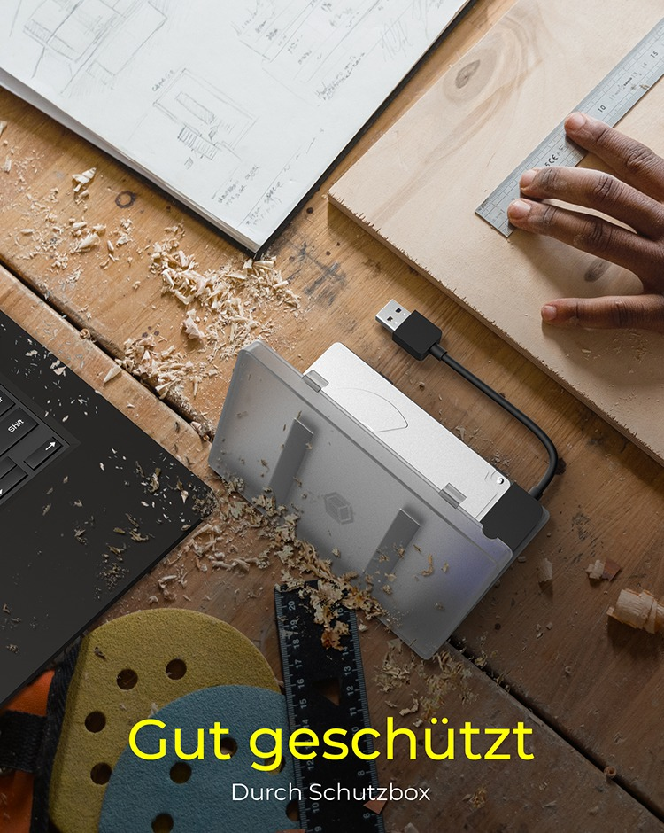 Arbeitsplatz mit Laptop, Holzbrett und USB-Hub. Text im Bild.