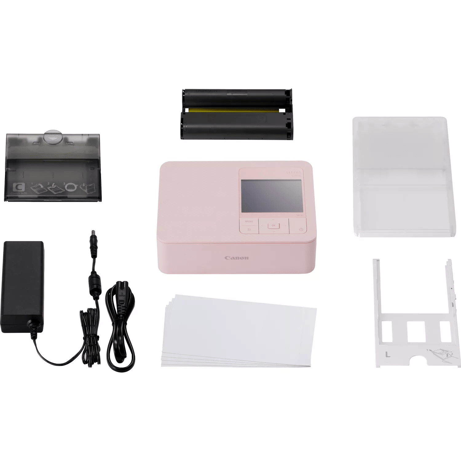 Impresora fotográfica Canon rosa con accesorios, incluyendo papel y fuente.