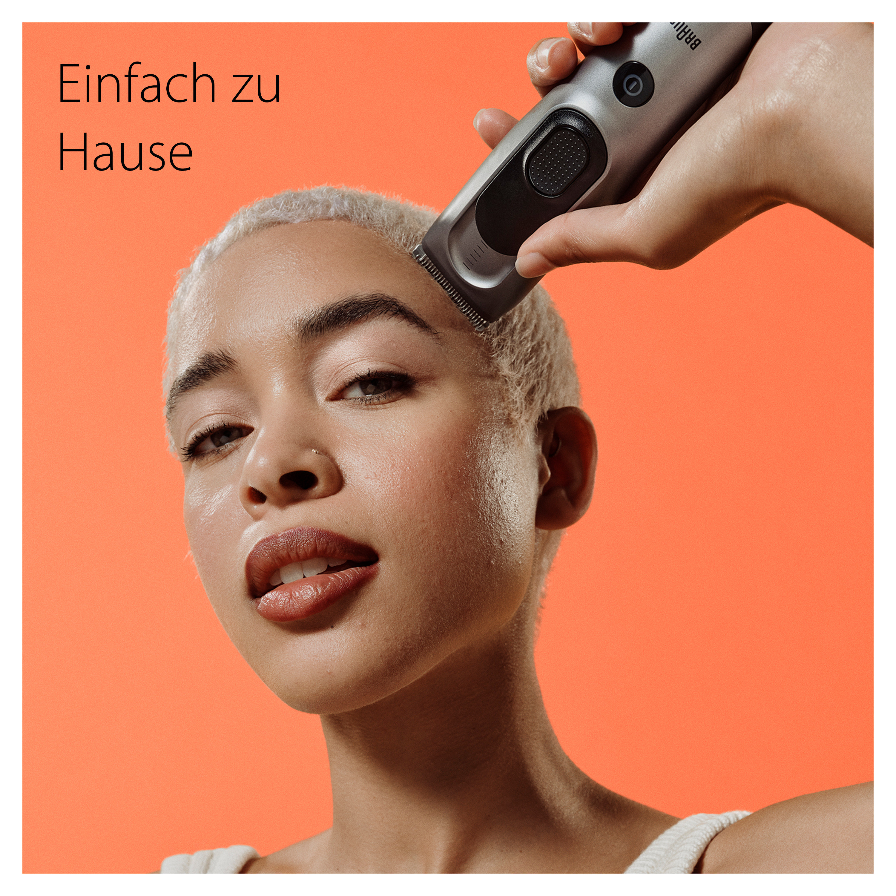 Frau mit kurzen blonden Haaren und eine Person, die einen Trimmer benutzt.