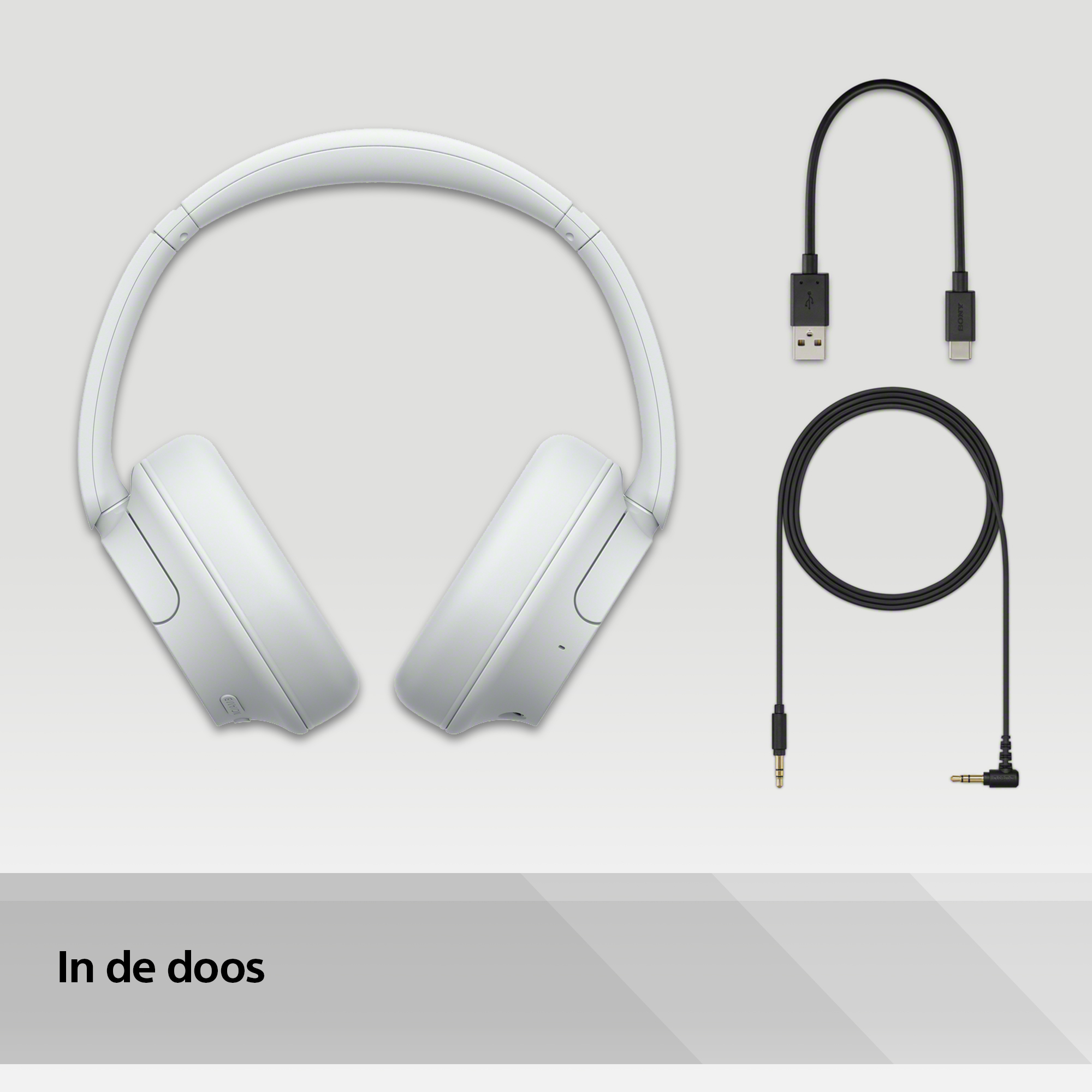 Casque blanc, câbles et emballage. Le casque et les câbles sur une surface gris clair.