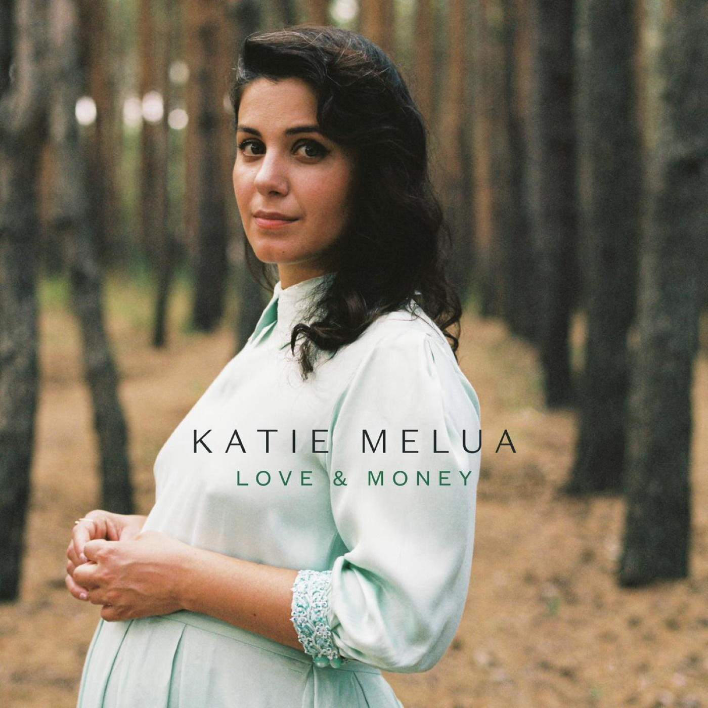 Album borító. Katie Melua világoskék ruhában, erdőben pózol. Szöveg: Love & Money.