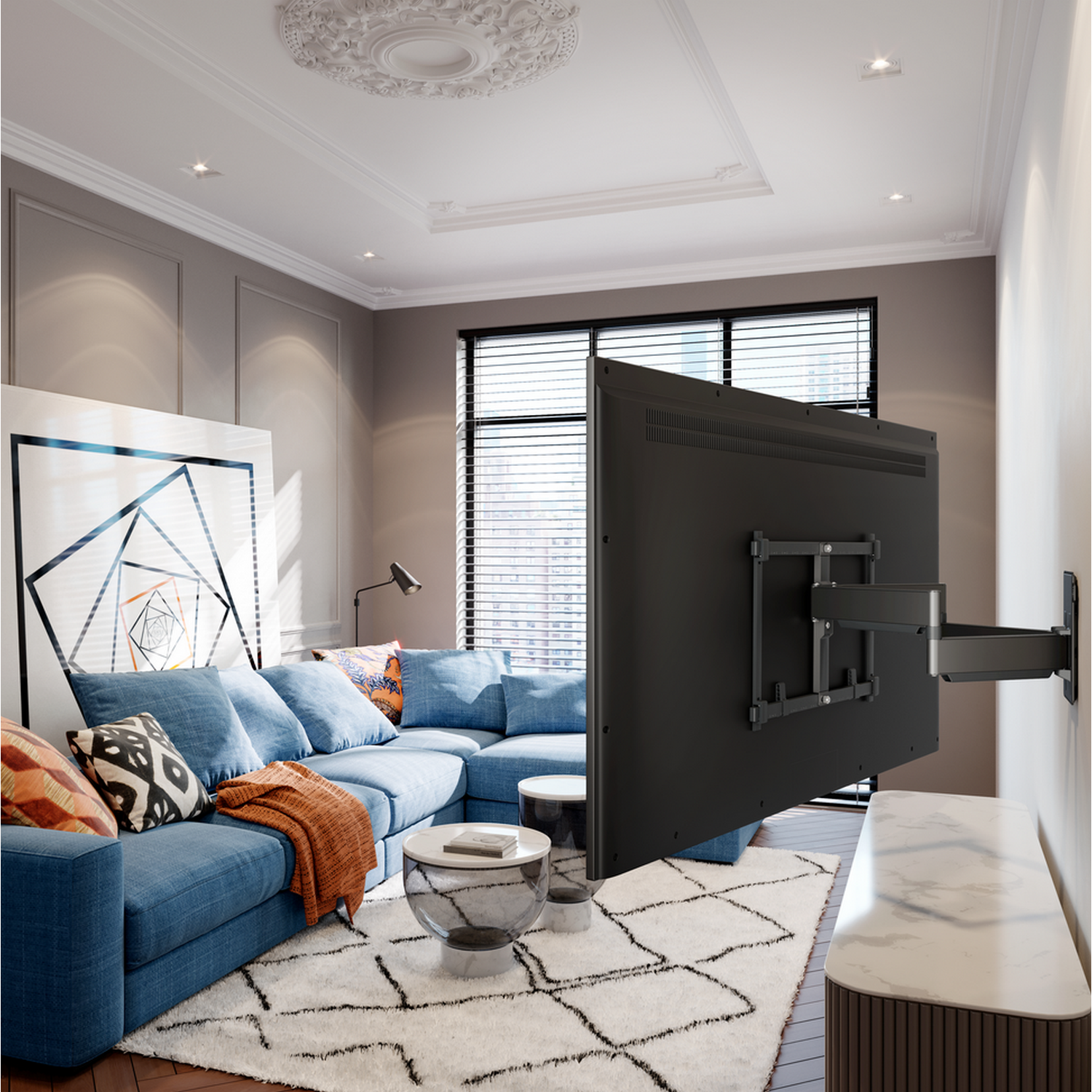 A large TV mounted on a wall, with a blue couch and a rug in front of it.