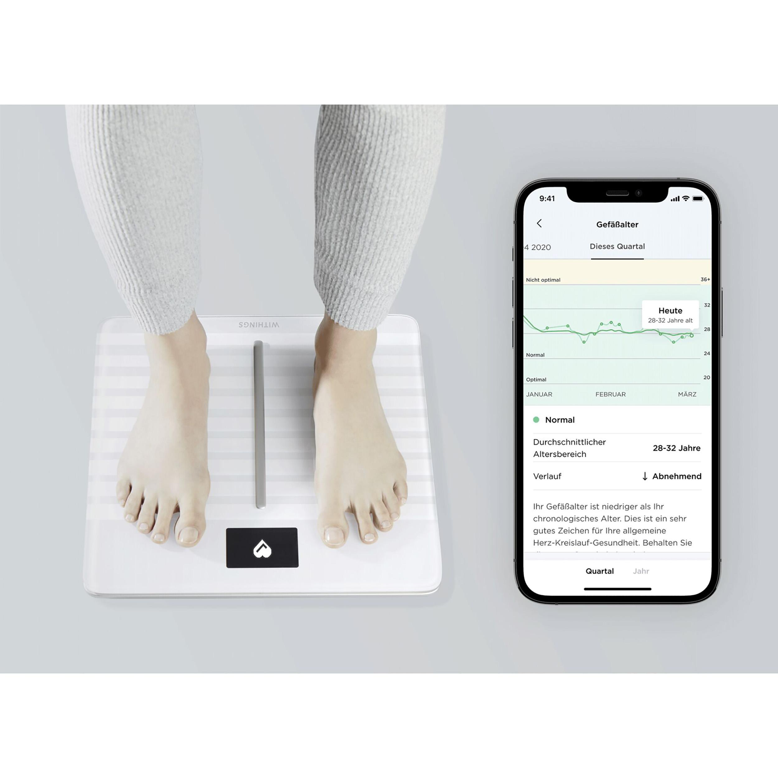 Person steht auf weißer Waage neben Telefon, das Gesundheitsdaten-Diagramme anzeigt.