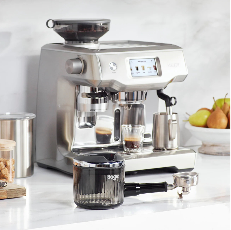 Silberne Espressomaschine mit Zubehör auf einer Theke.