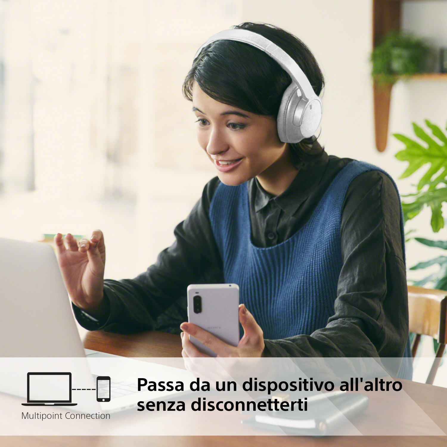 Donna che usa cuffie bianche, interagisce con un laptop e uno smartphone. Testo: Connessione multipunto.
