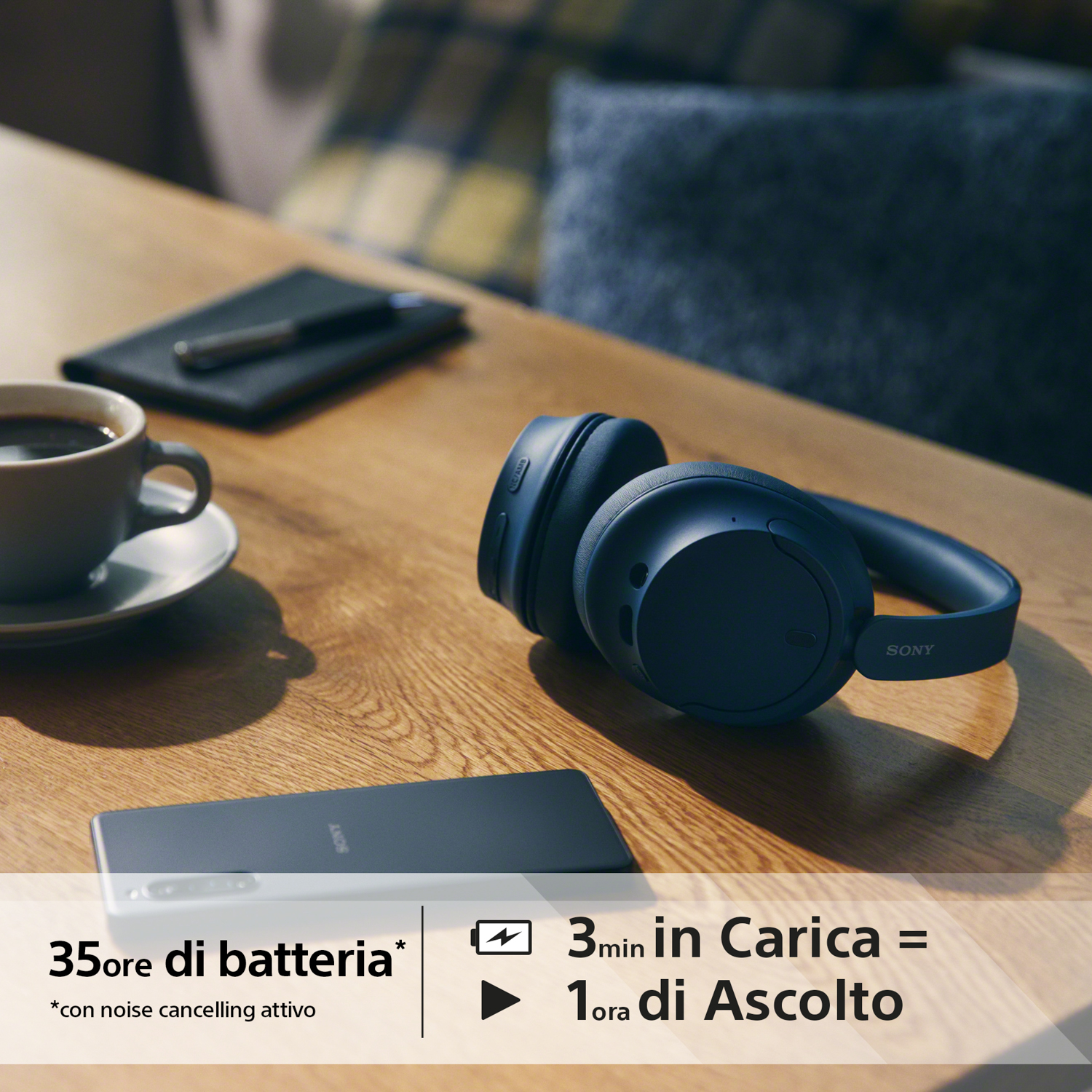 Cuffie e telefono su un tavolo, con testo sulla batteria e la ricarica.