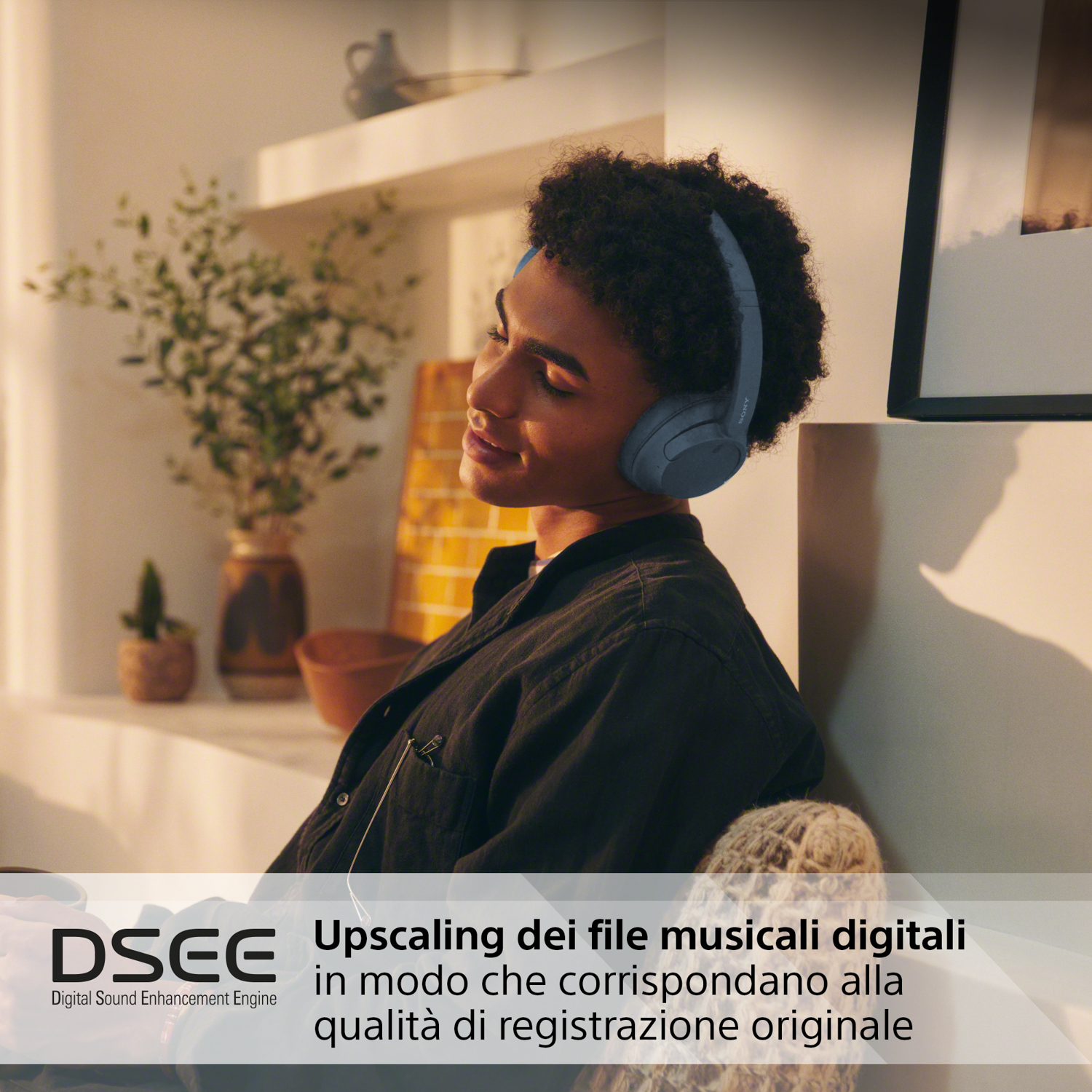 Una persona con cuffie blu, seduta al chiuso. Il testo recita 'Upscaling dei file musicali digitali'.