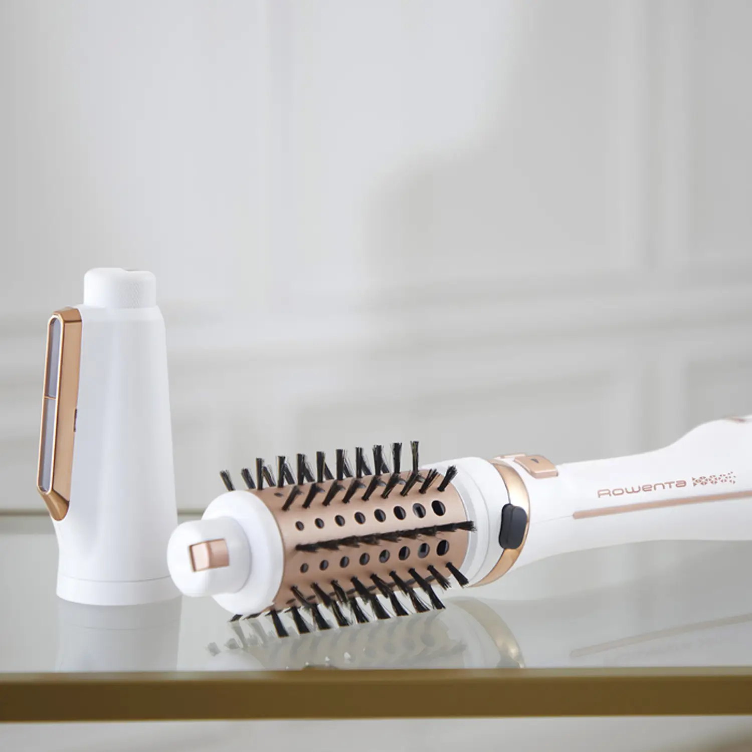 Brosse à coiffer et une partie séparée, toutes deux blanches avec des accents or rose.