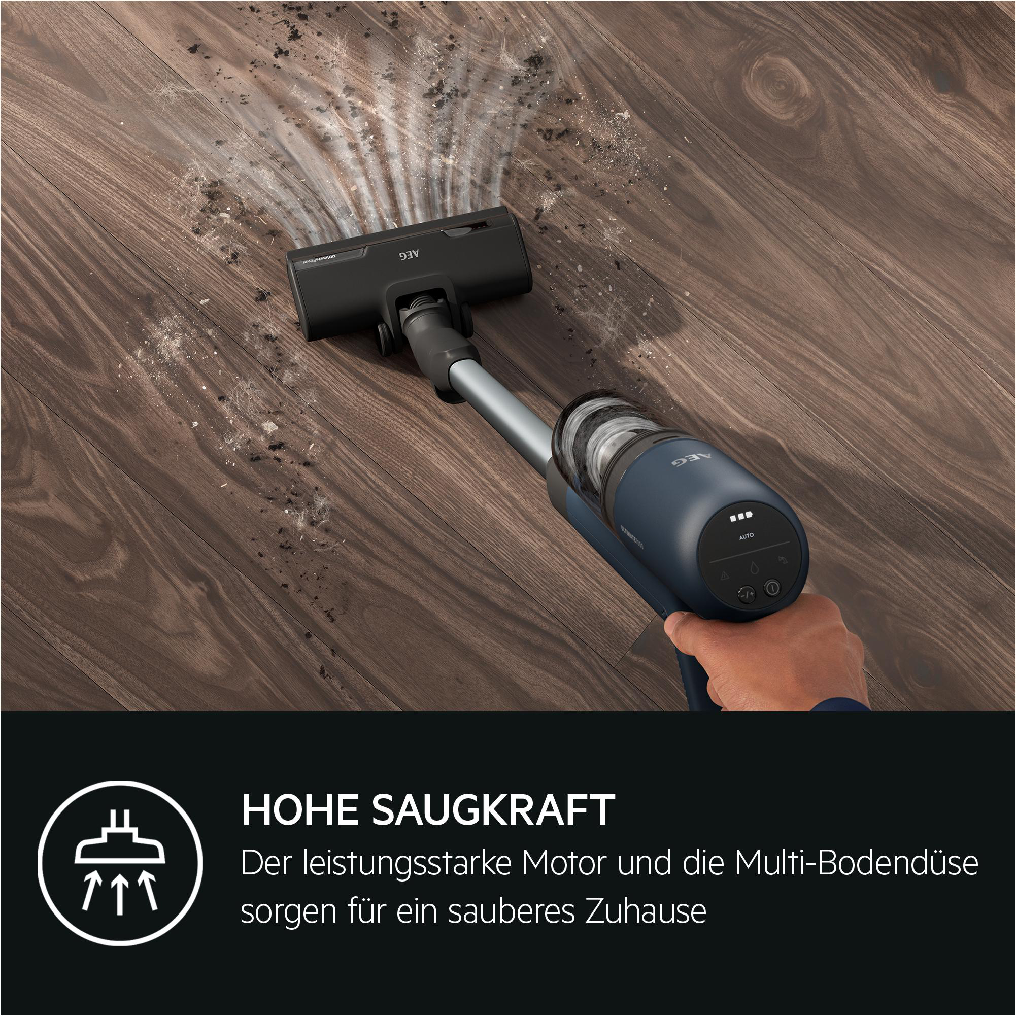 Ein Staubsauger reinigt einen braunen Holzboden. Der Staubsauger ist blau und grau.