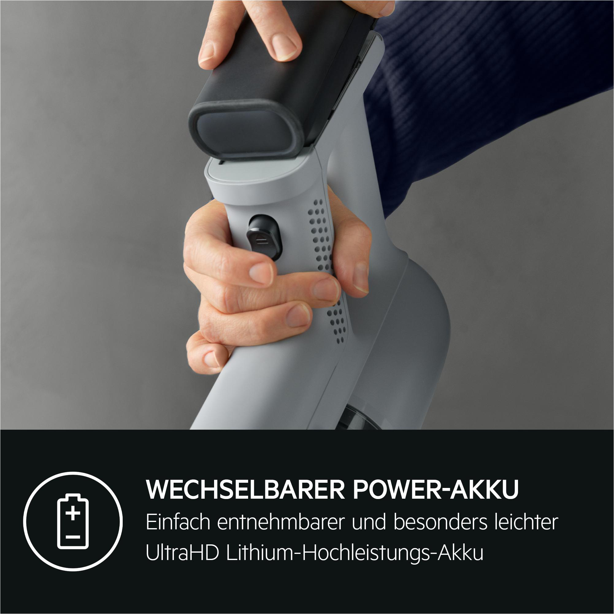 Hände, die einen schwarzen Akku in einen grauen Staubsauger einsetzen, dunkler Hintergrund mit Text.