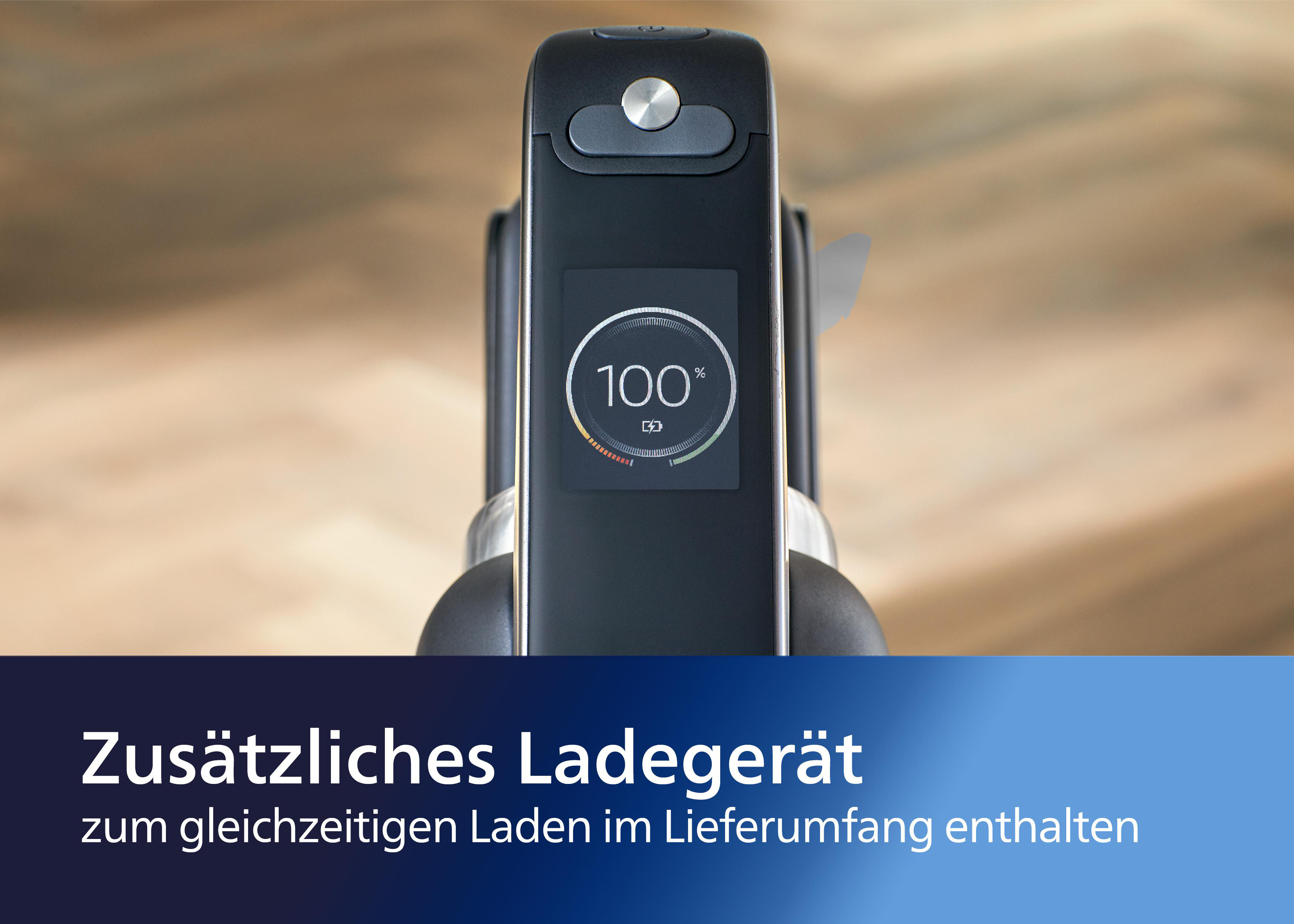 Bildschirm der Ladestation zeigt 100 % Ladung an. Text auf Deutsch: Zusatzliches Ladegerät. Holz Hintergrund.
