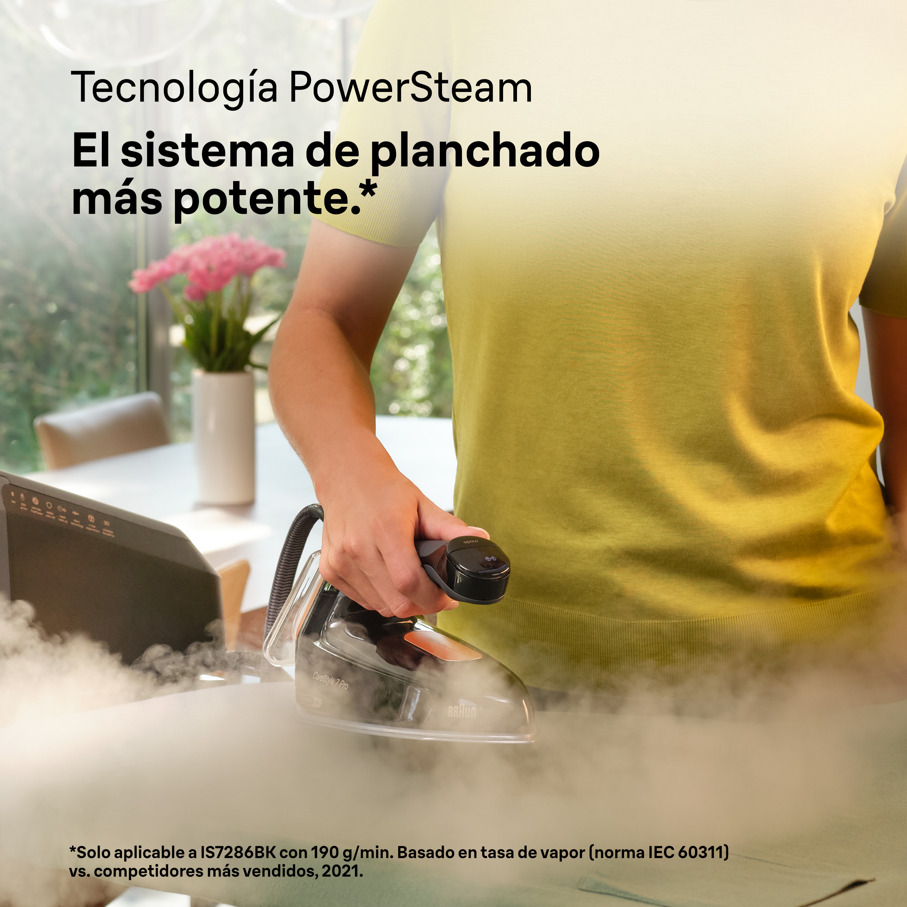Mujer planchando con plancha de vapor. El vapor sale de la plancha, sobre una tela gris.