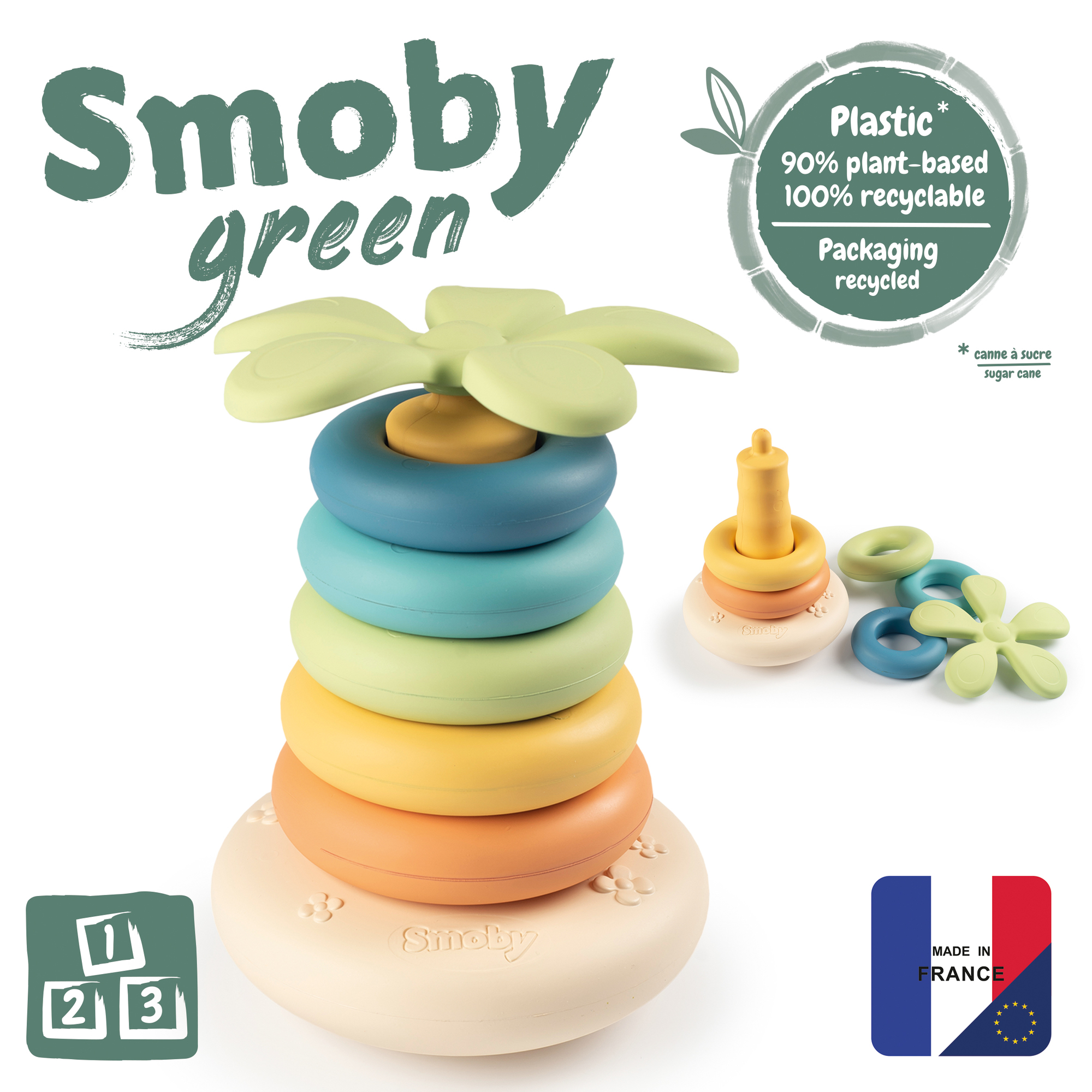 Stapelspielzeug mit grünen, blauen, gelben, orangefarbenen Ringen. Blumenspitze. Verpackung ist recycelt.