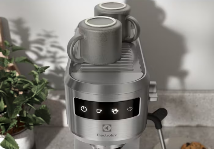 Rozsdamentes acél Electrolux eszpresszógép két bögrével a tetején. Bekapcsolás, kávé, gőz ikonok.