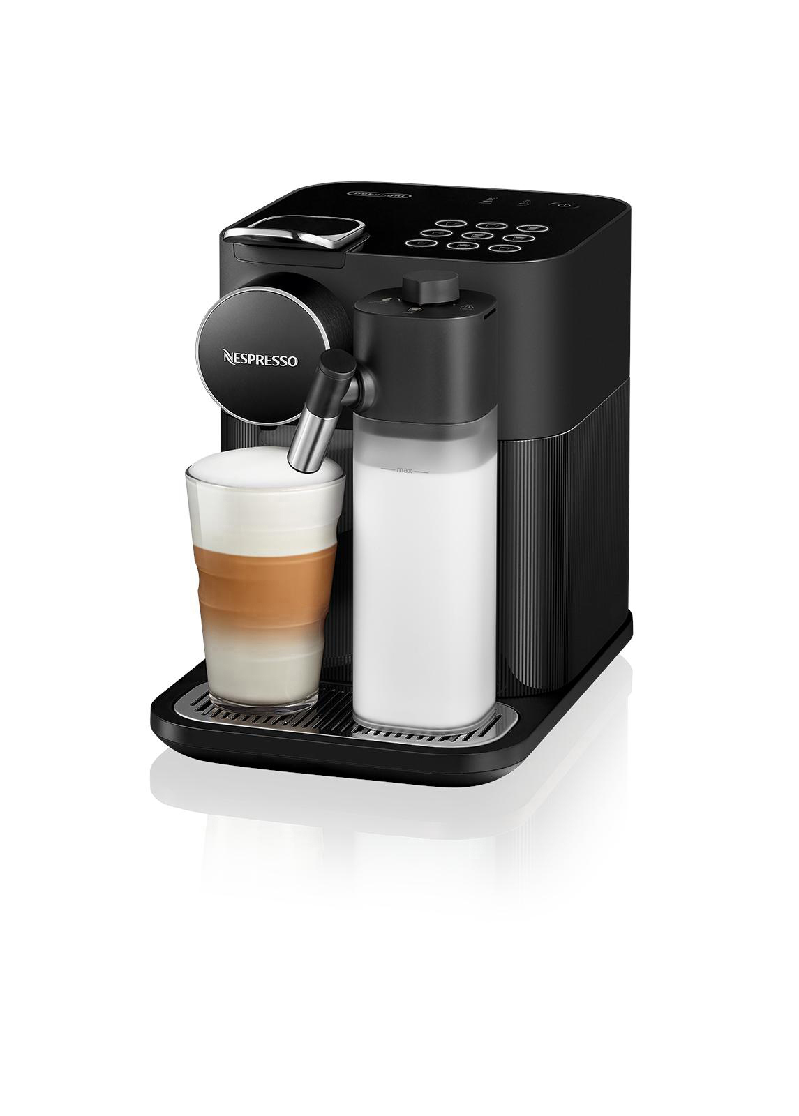 Schwarze Nespresso-Kaffeemaschine mit einem Glas Latte. Ein Milchbehälter befindet sich an der Seite.