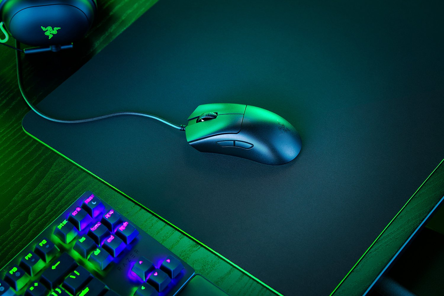 Eine schwarze Maus auf einem schwarzen Mauspad mit Tastatur.