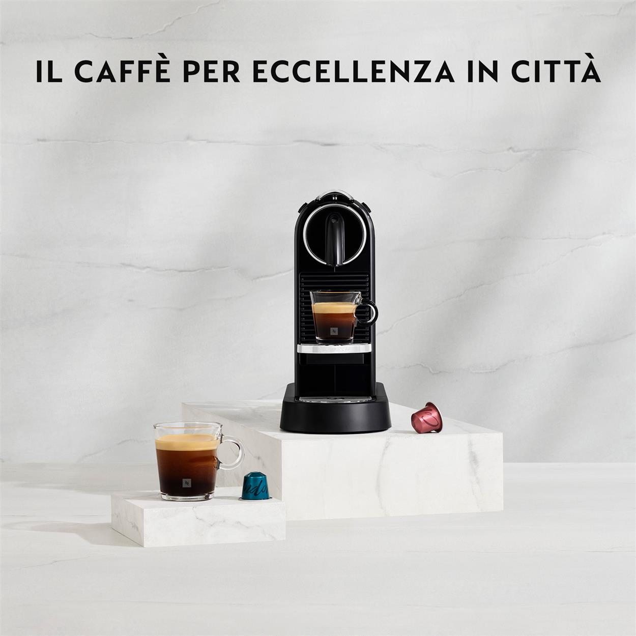 Eine schwarze Nespresso-Maschine mit einem Glas Kaffee und zwei Kapseln.