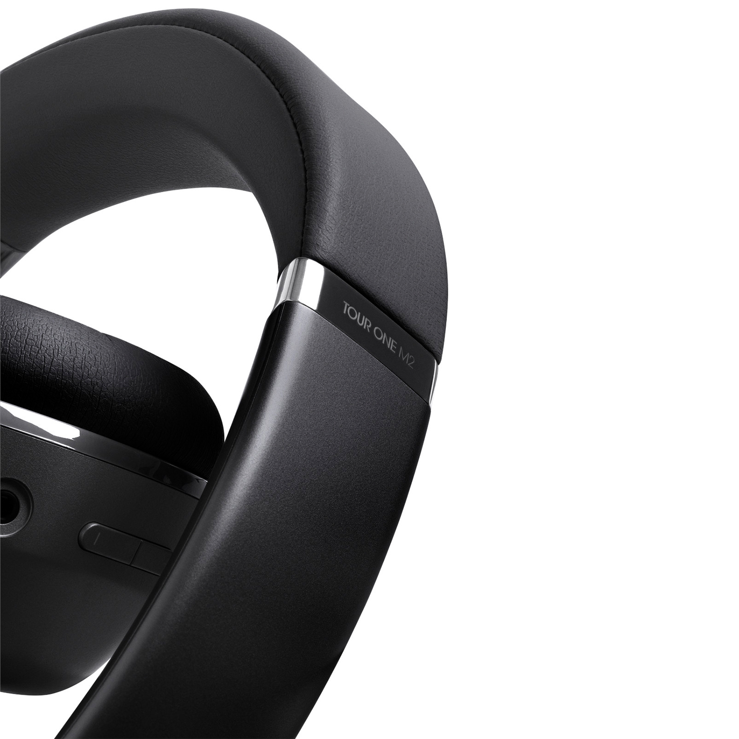Cuffie nere, parzialmente visibili, con la scritta "TOUR ONE M2" sul lato.