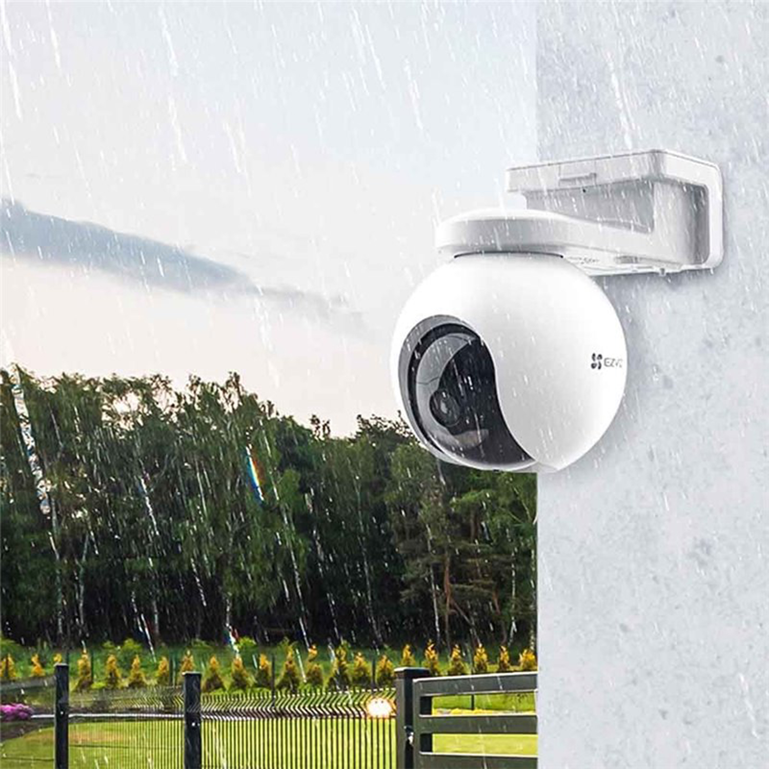 Telecamera di sicurezza bianca montata su un muro sotto la pioggia.