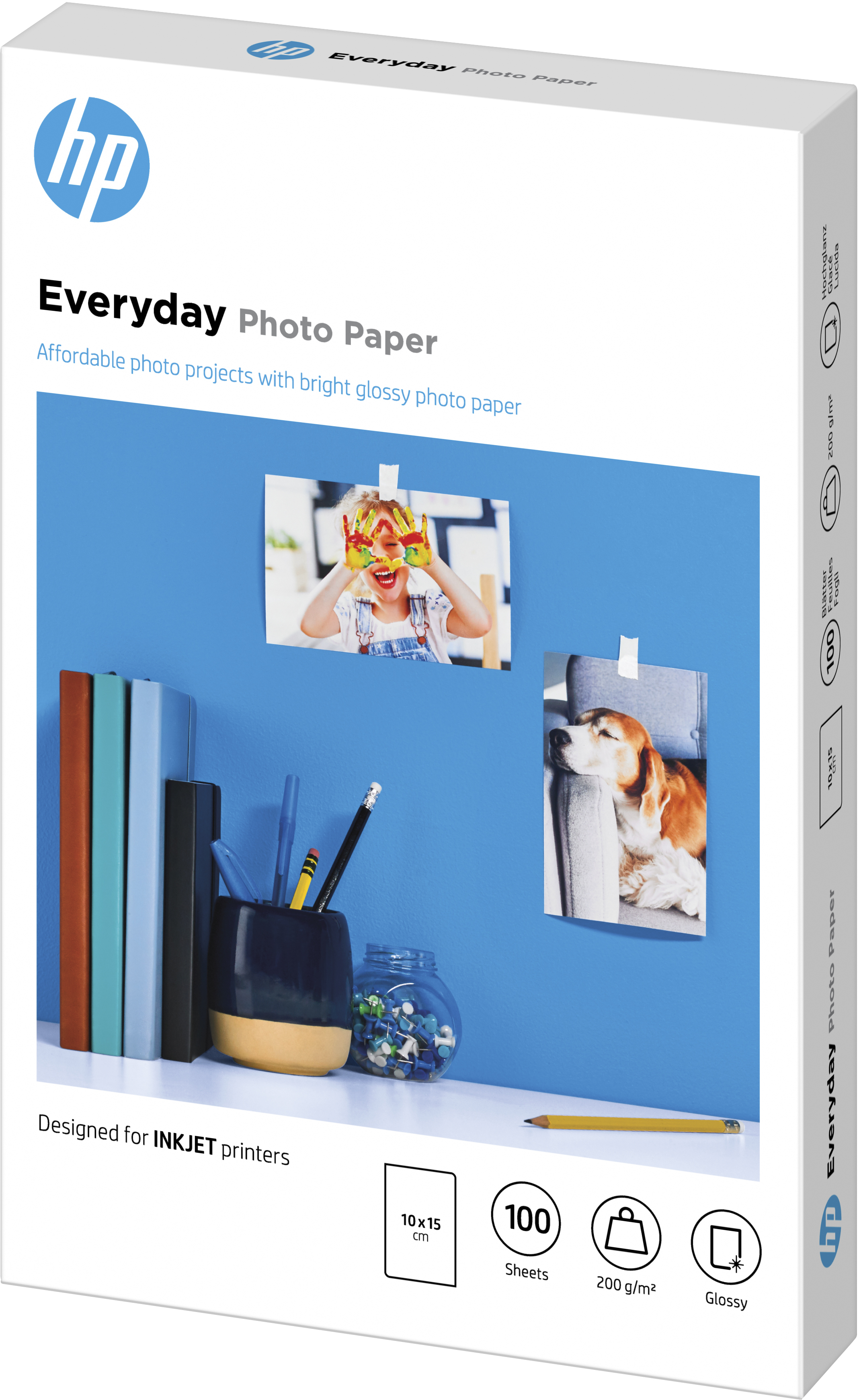 Eine Schachtel HP Everyday Fotopapier mit Fotos an einer blauen Wand mit Stiften.