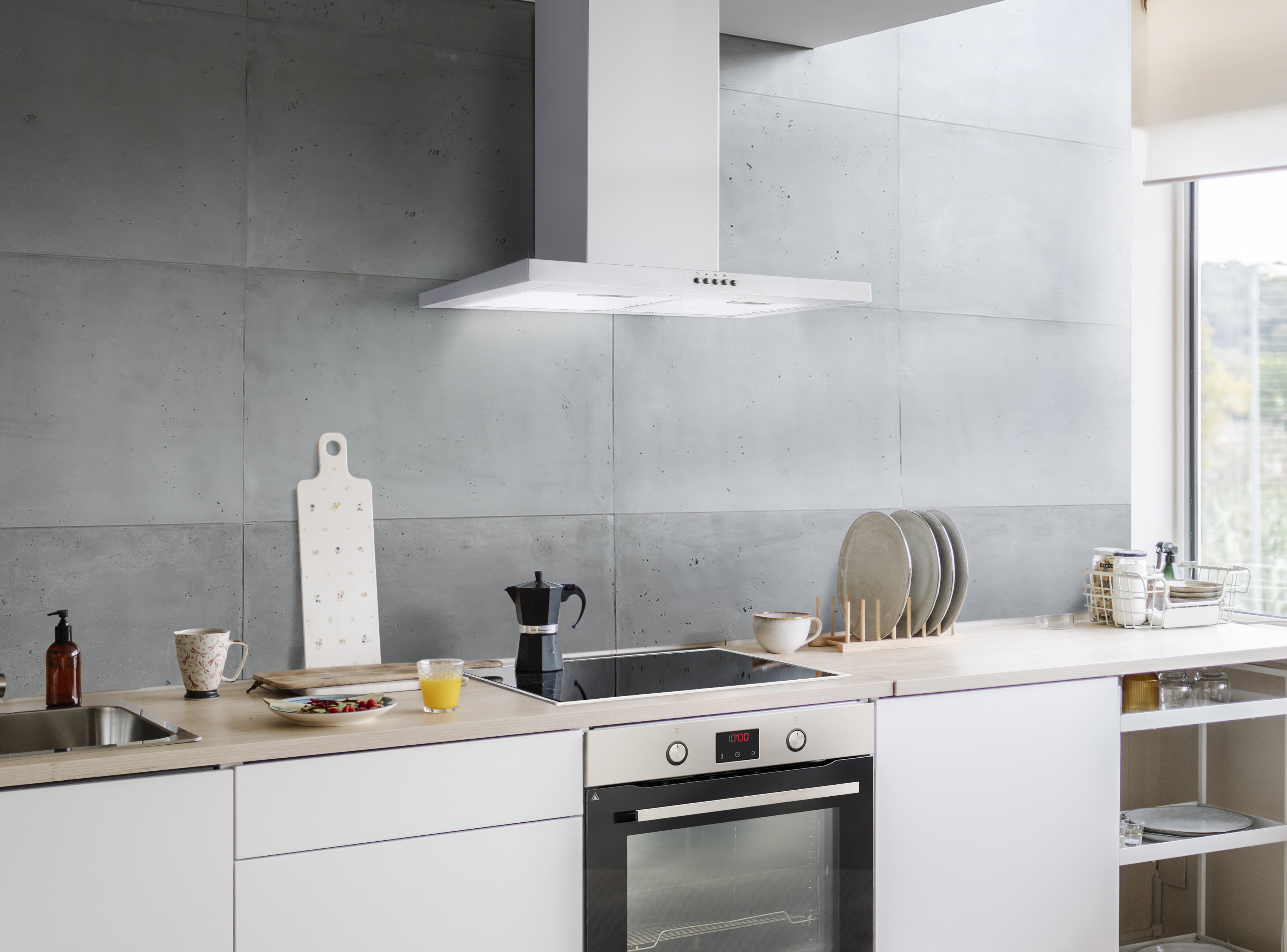 Escena de cocina moderna con gabinetes blancos, pared de concreto y electrodomésticos.
