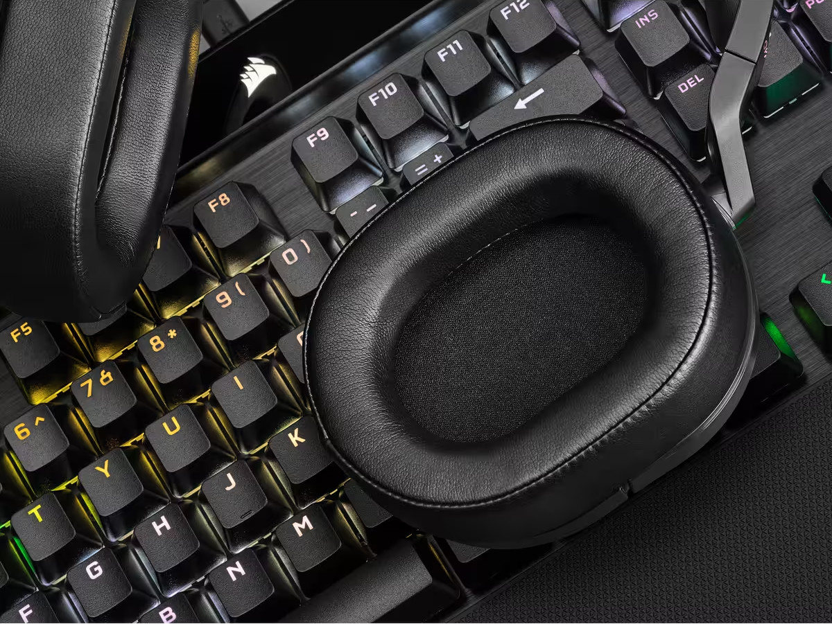 Un casque noir sur un clavier. Les touches du clavier sont éclairées de différentes couleurs.