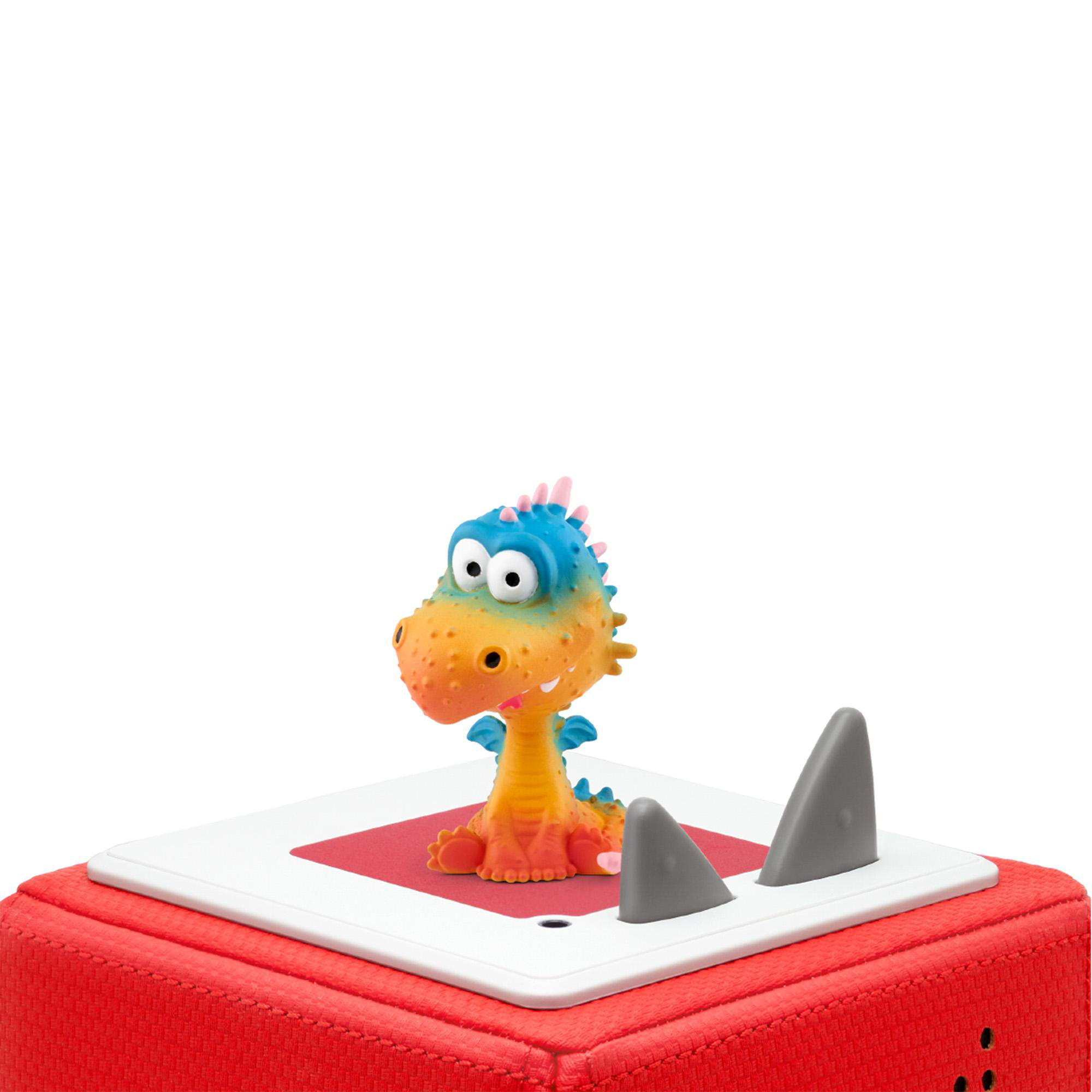 Ein Spielzeugdrache auf einem roten Block mit hai-flossenförmigen Objekten.