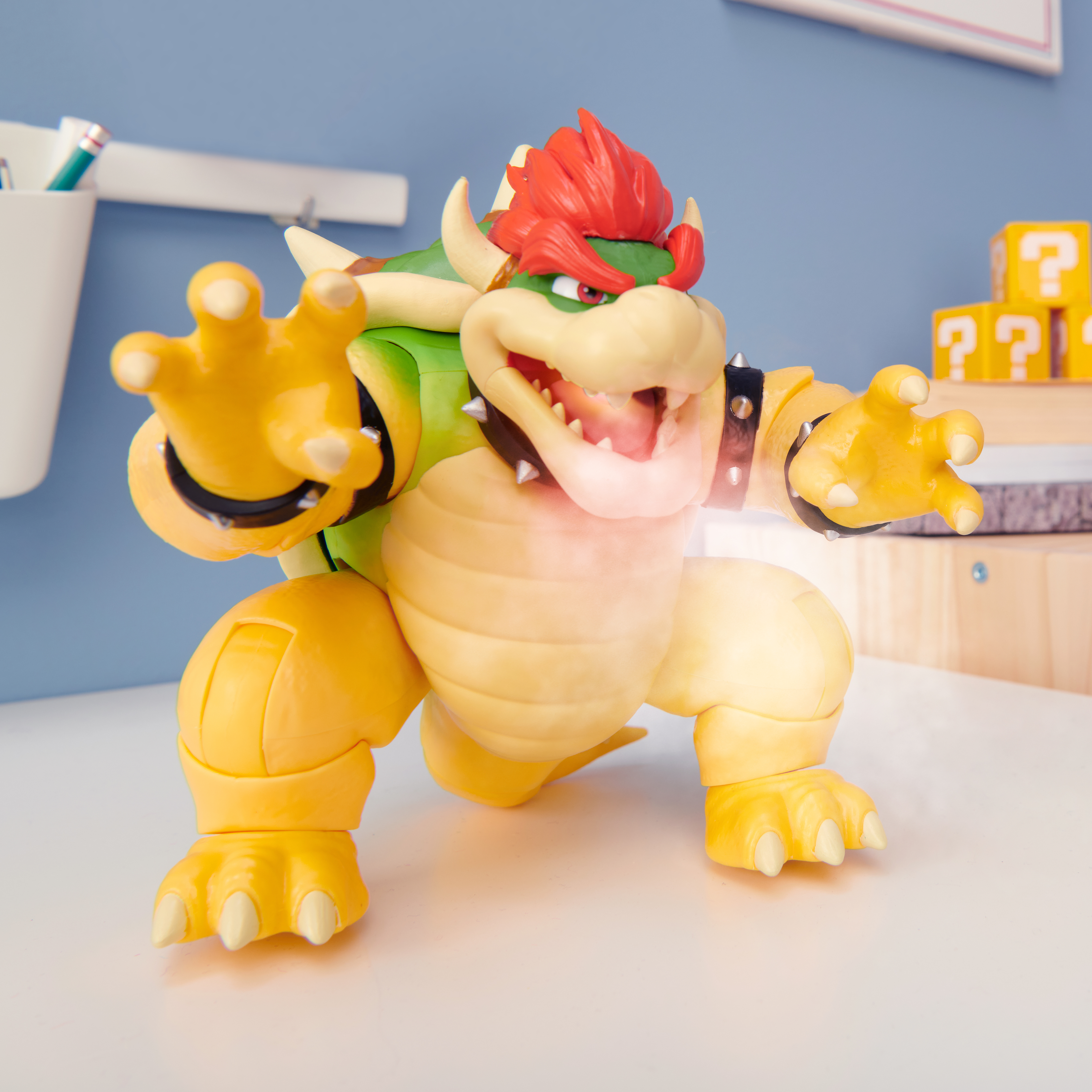 Bowser-Figur in aggressiver Pose auf weißem Tisch. Helle Farben.