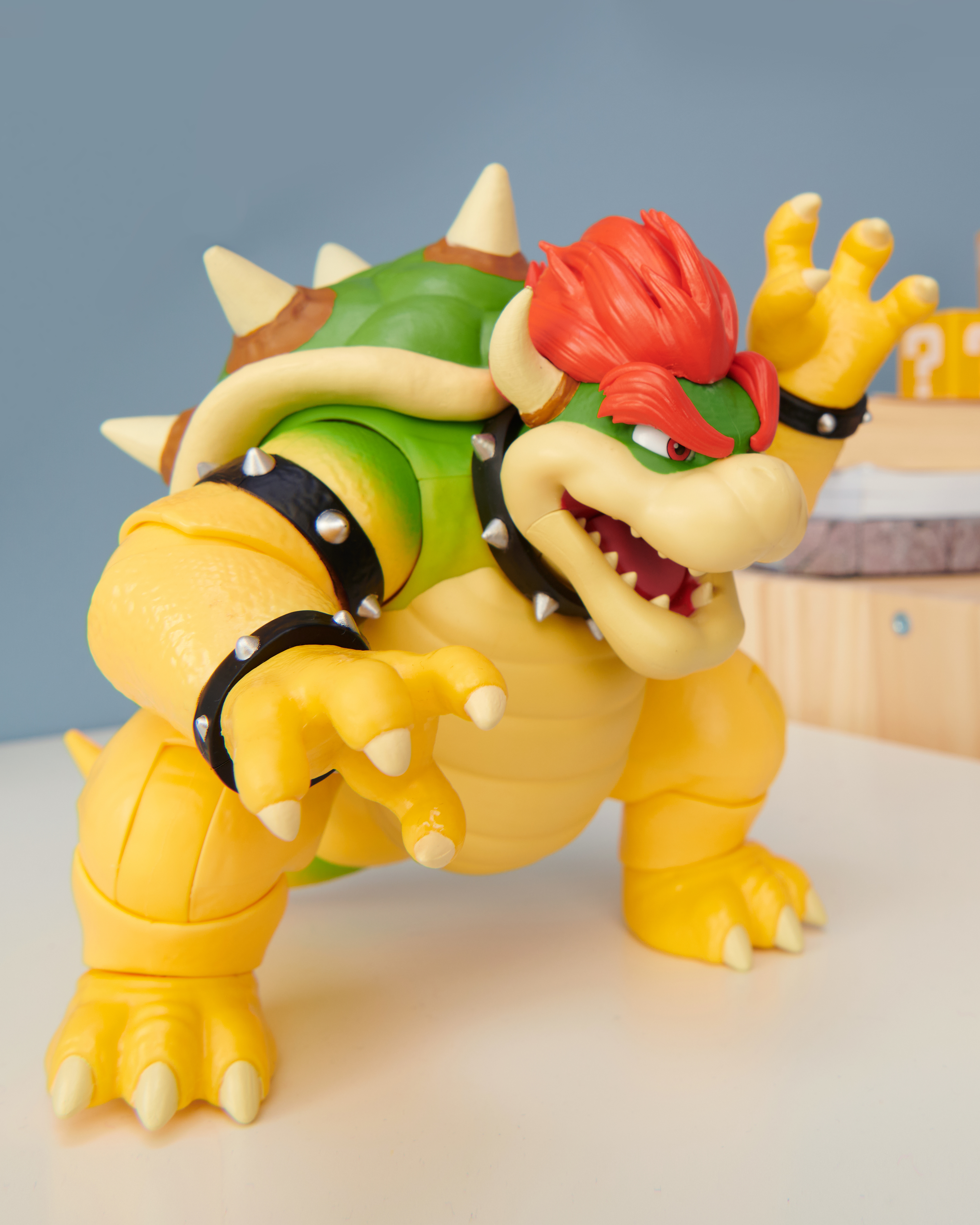 Bowser-Spielfigur. Grün, Gelb und Orange. Stachelpanzer, rote Haare, offener Mund und schwarze Armbänder.