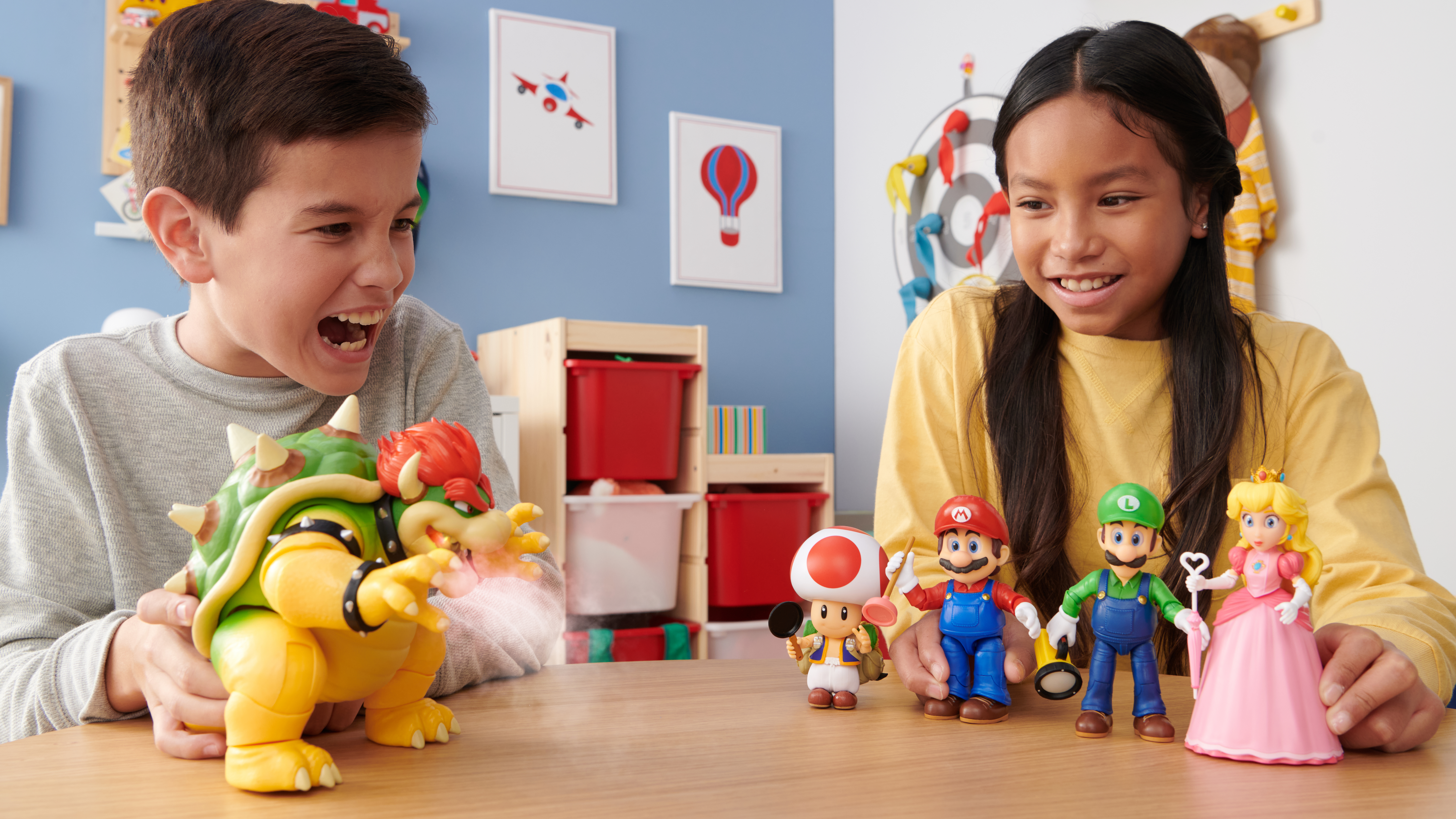 Kinder spielen mit Mario-Figuren, Bowser im Vordergrund.