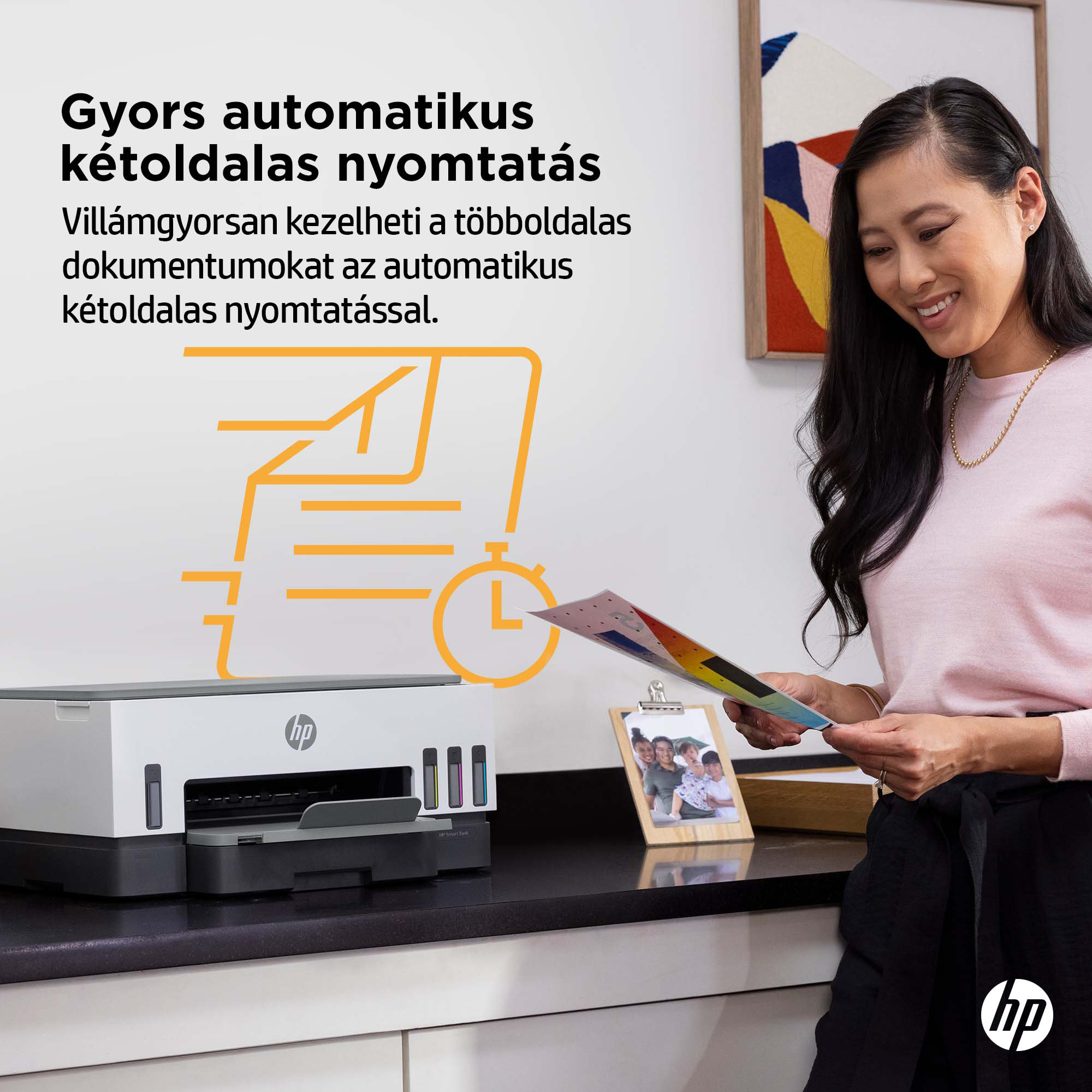 Egy mosolygó nő egy nyomtató közelében, amely papírokon nyomtatási eredményeket mutat.