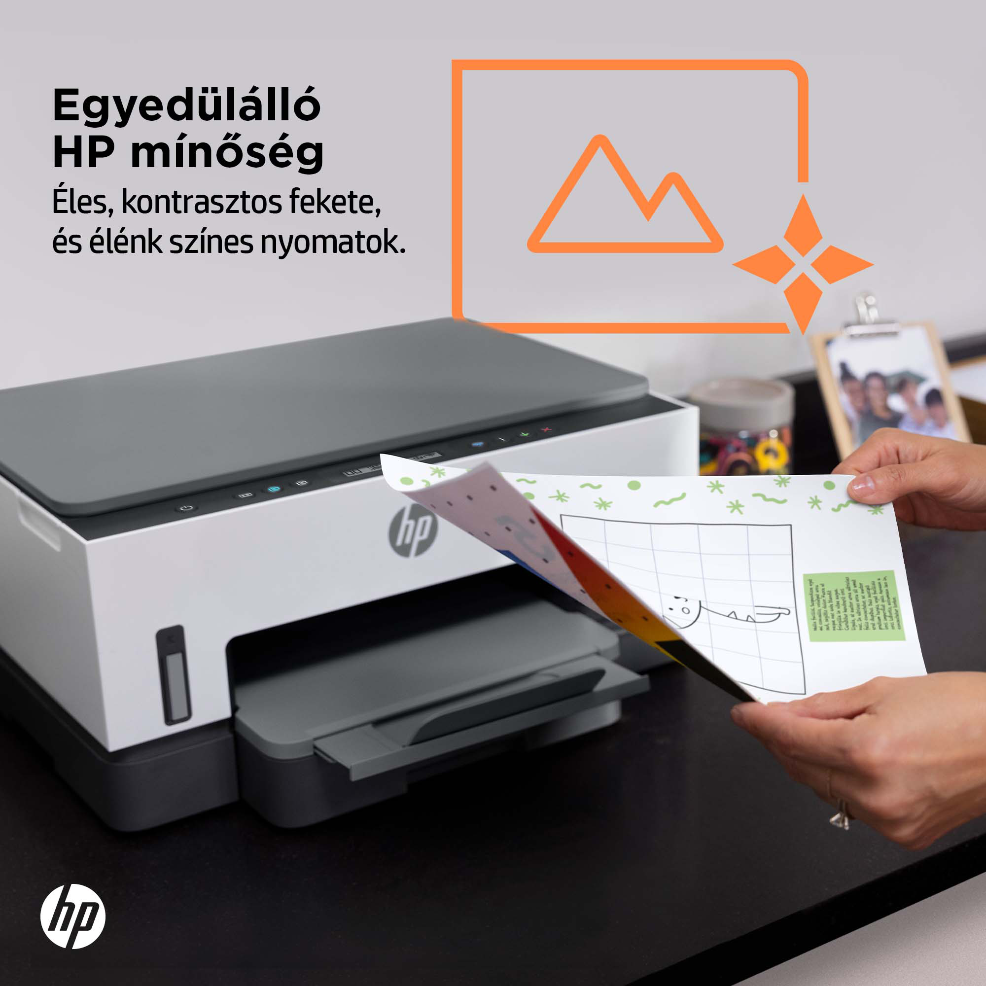 Egy nyomtató színes rajzot nyomtat. A szöveg azt mondja, 'HP minőség' és 'Éles fekete'.
