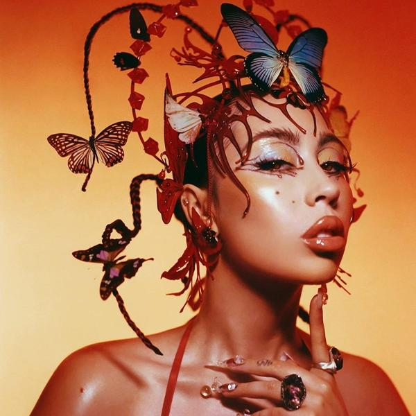 Frau mit Schmetterlings-Haarschmuck, rotes Kleid, orangefarbener Hintergrund. Make-up, Handgeste.