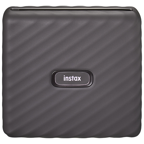 Ön yüzünde tırtıklı bir yüzeye ve Instax logosuna sahip gri bir Instax yazıcı.