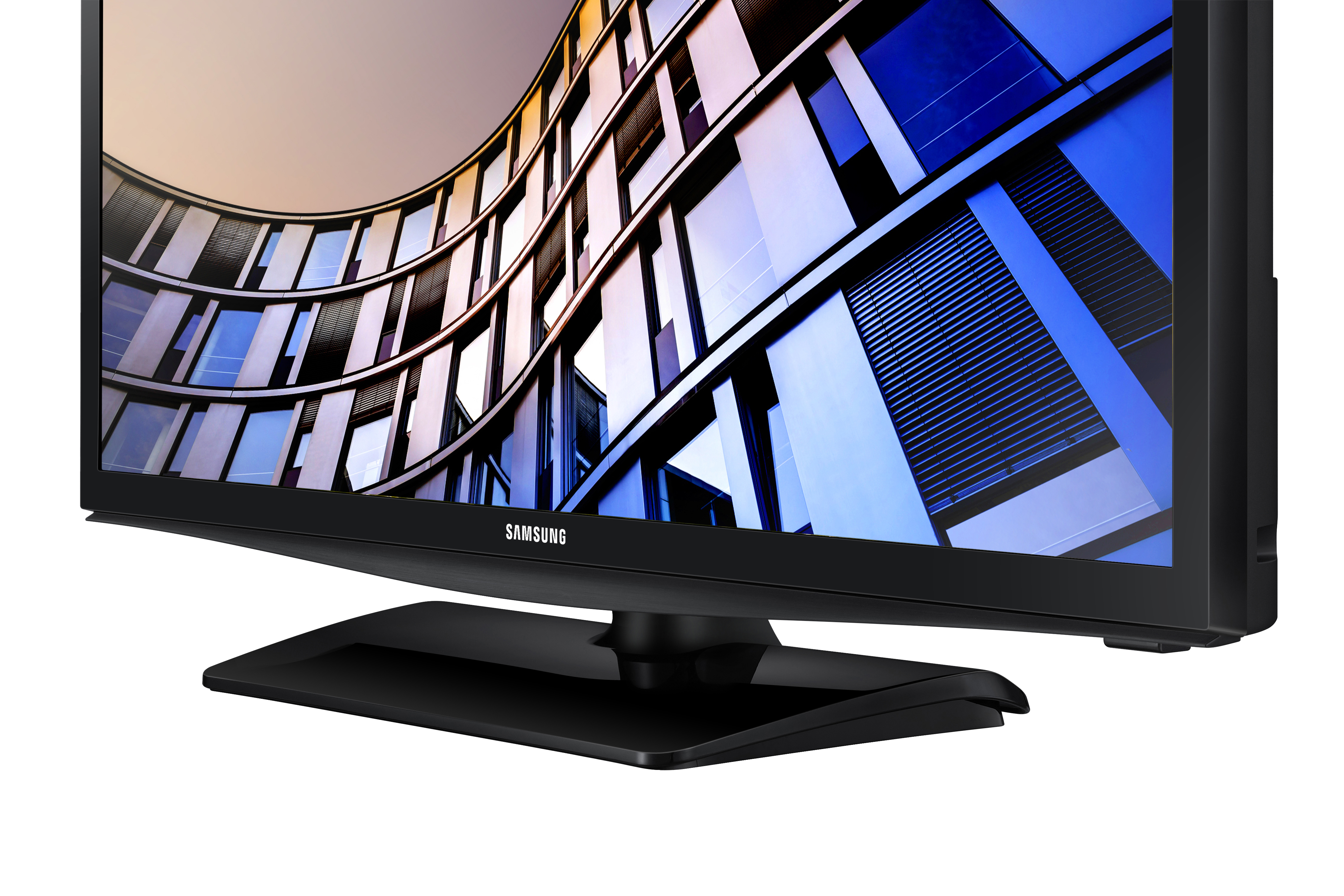 Televisor Samsung negro sobre un soporte. La pantalla muestra un edificio curvo con ventanas azules.