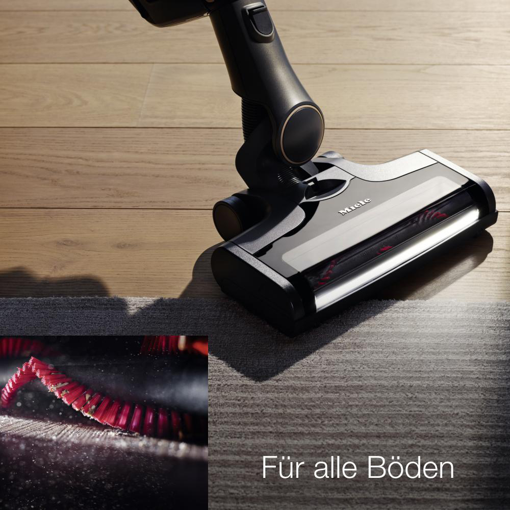 Ein Staubsauger reinigt einen Teppich. Es gibt eine Nahaufnahme der Bürste. Text sagt Für alle Böden.