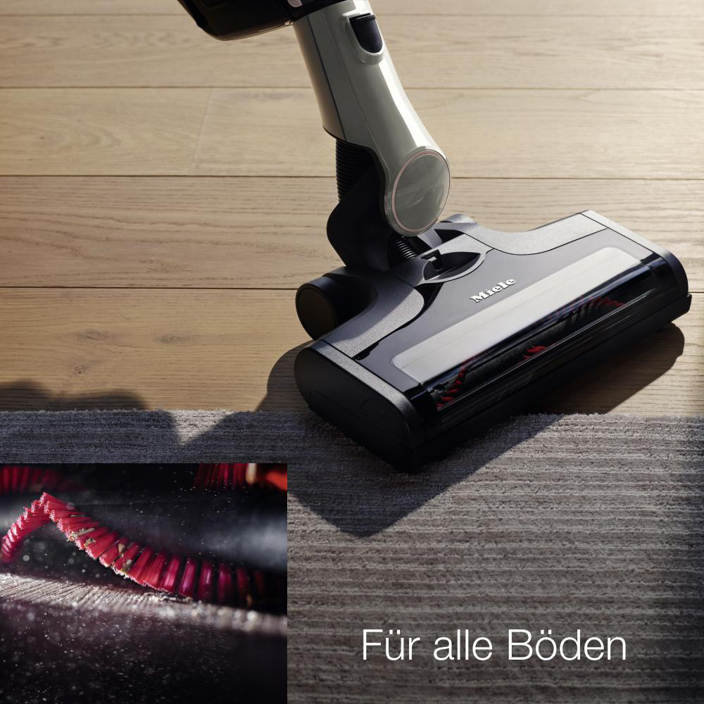 Staubsaugerkopf auf einem Teppich, mit Nahaufnahme der Bürste.