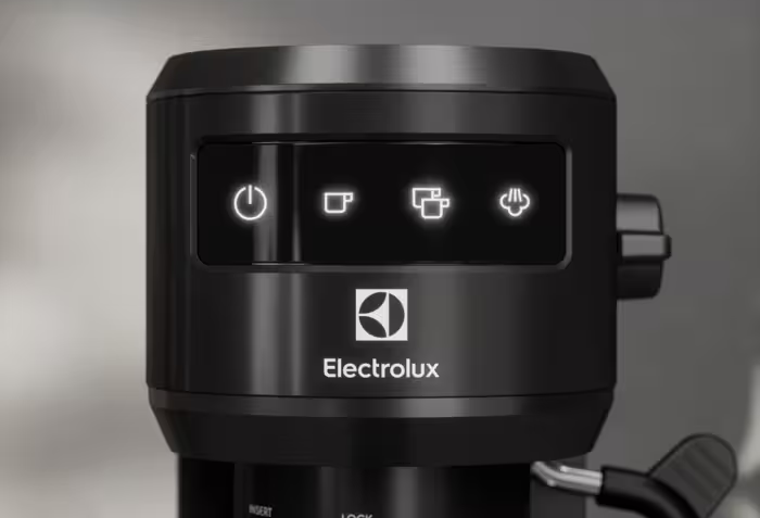 Közelkép egy fekete Electrolux kávéfőzőről. A bekapcsolás, a kávé és a gőz megvilágított ikonjai láthatók felül.