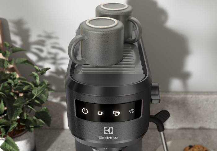 Egy fekete Electrolux kávéfőző közeli képe, két bögrével a tetején.