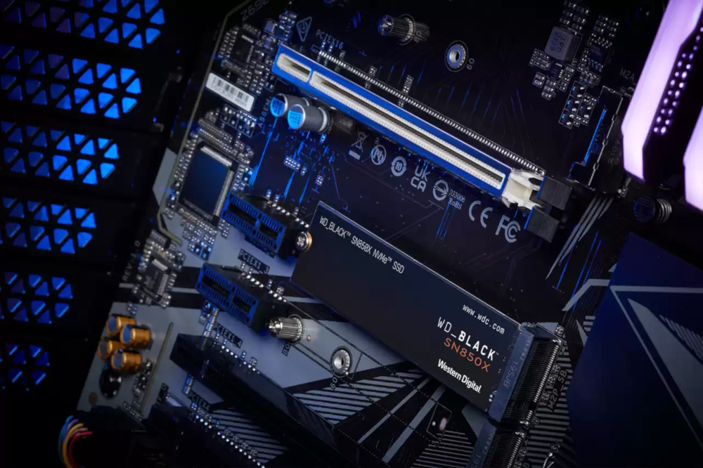 Computer components: a motherboard with a WD_BLACK SN850X SSD installed, with blue lights.
