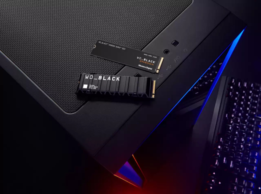 A computer case, with SSDs on top. Dark background and a keyboard on the right.