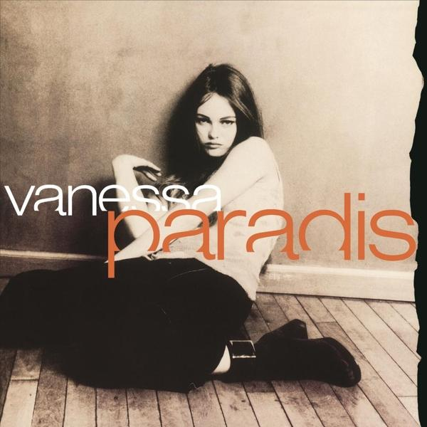 Albumhoes van Vanessa Paradis, poserend in casual outfit, zittend op houten vloer.