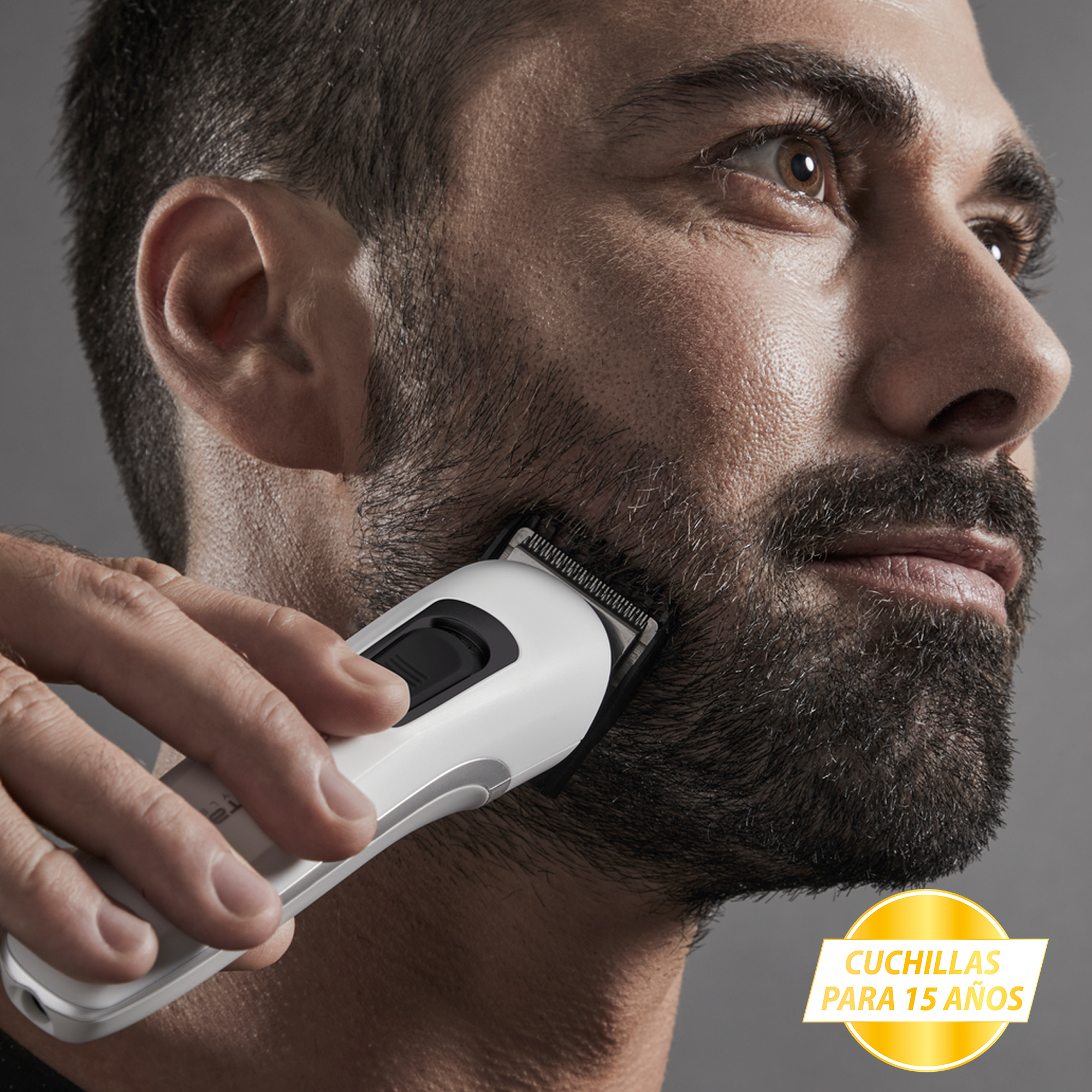 Un hombre se afeita la barba con una recortadora eléctrica.
