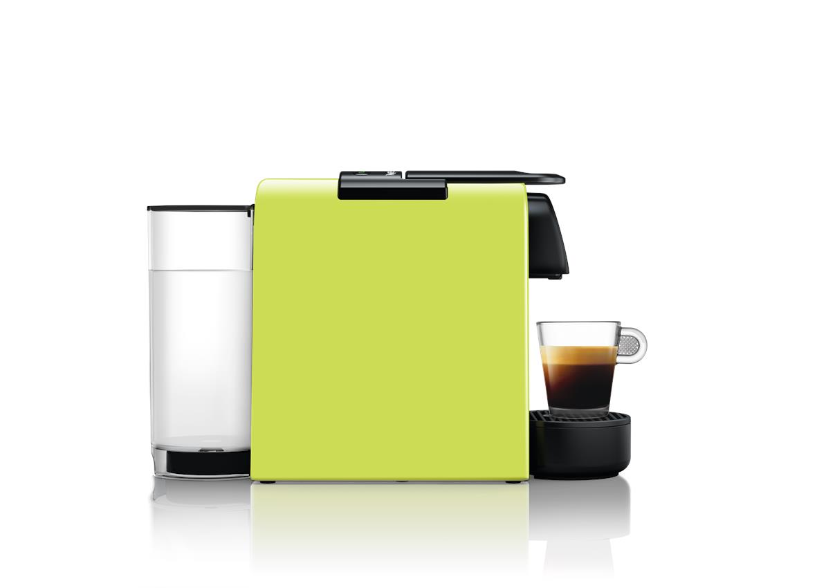 Beyaz arka plan üzerinde su haznesi ve bir bardak espresso ile birlikte kireç yeşili Nespresso makinesi.