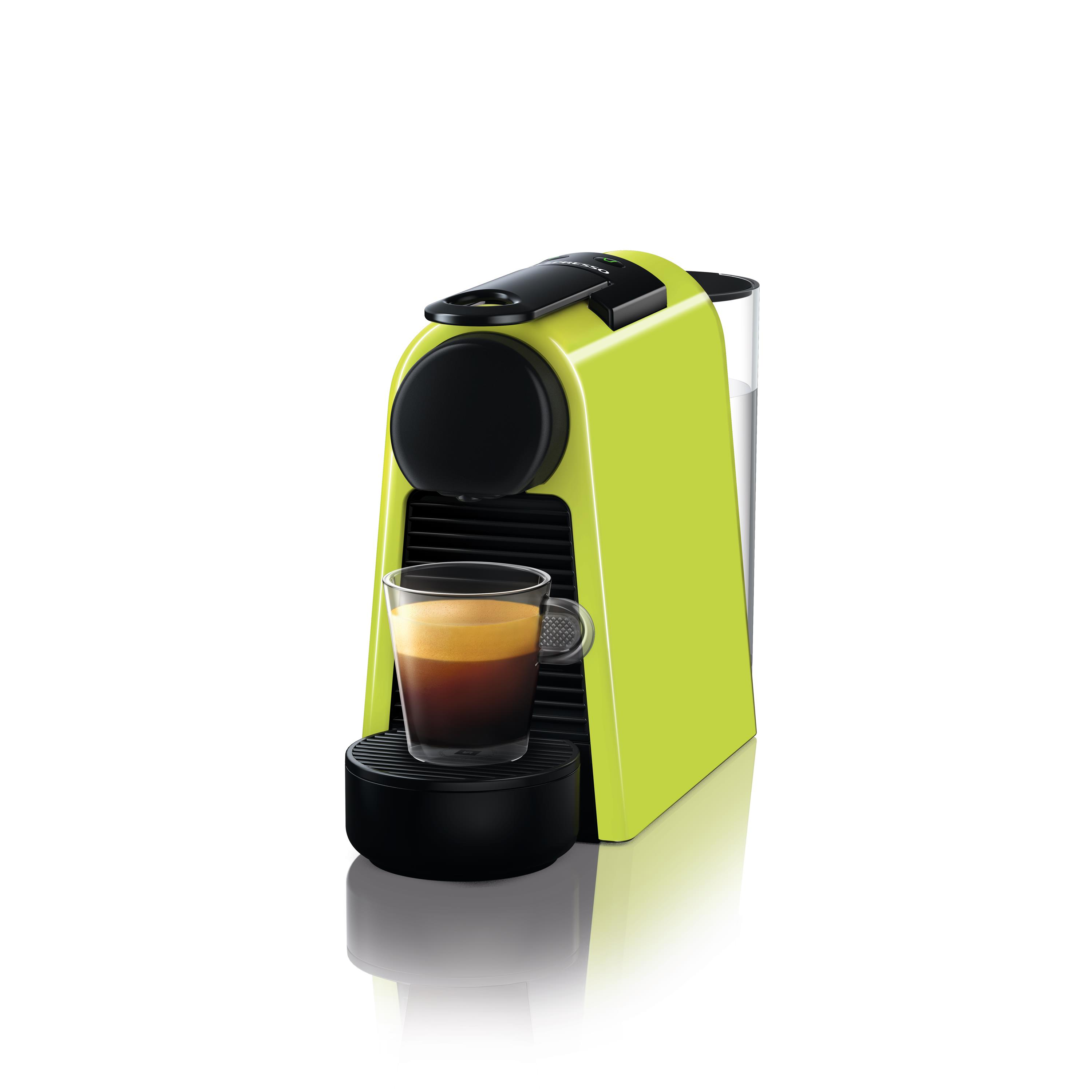 Bir bardak espresso ile birlikte kireç yeşili bir Nespresso makinesi. Makine beyaz bir yüzey üzerinde duruyor.