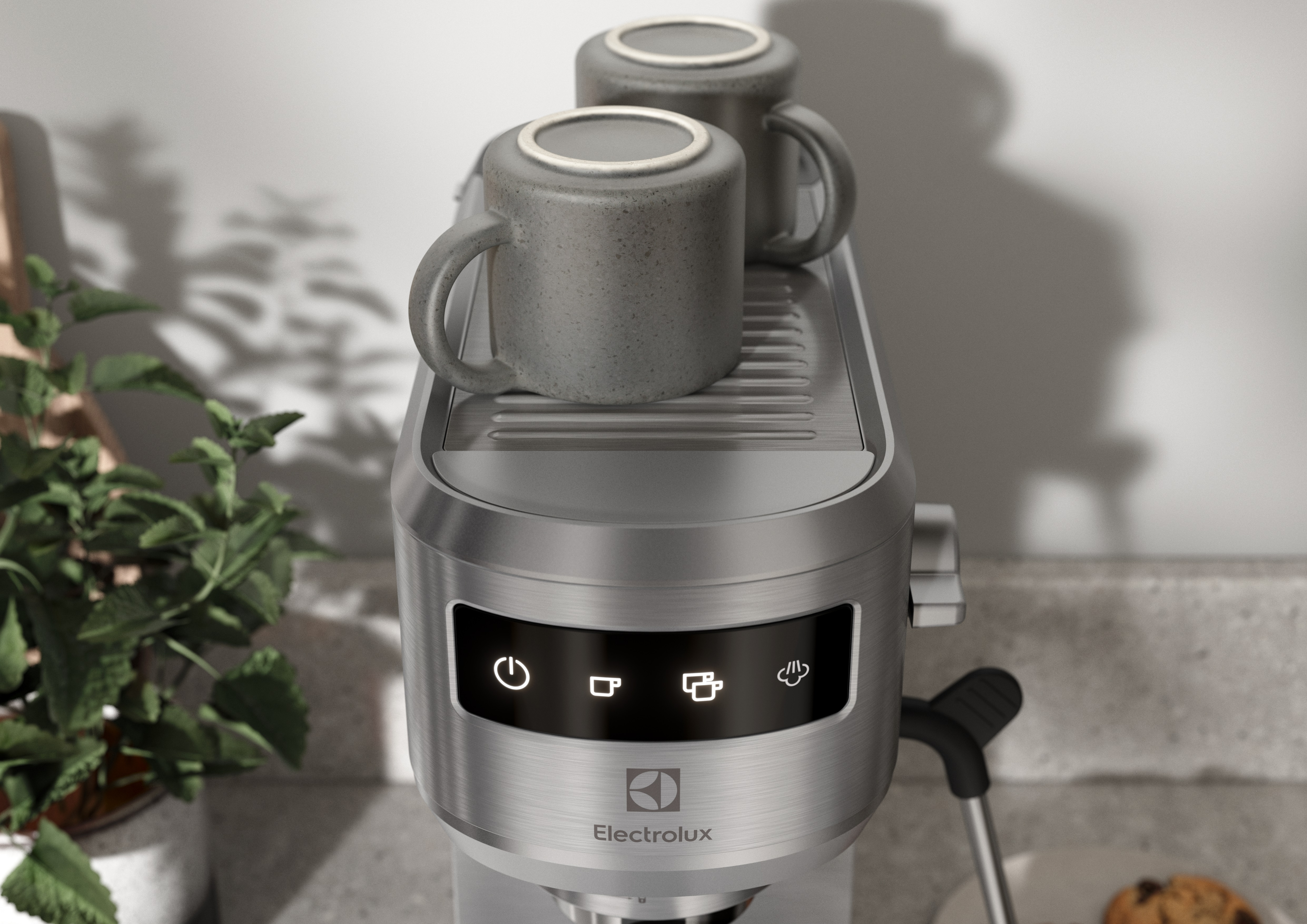 Üzerinde iki kupa bulunan bir espresso makinesinin yakın çekimi. Düğmeler ve Electrolux logosu görünür.